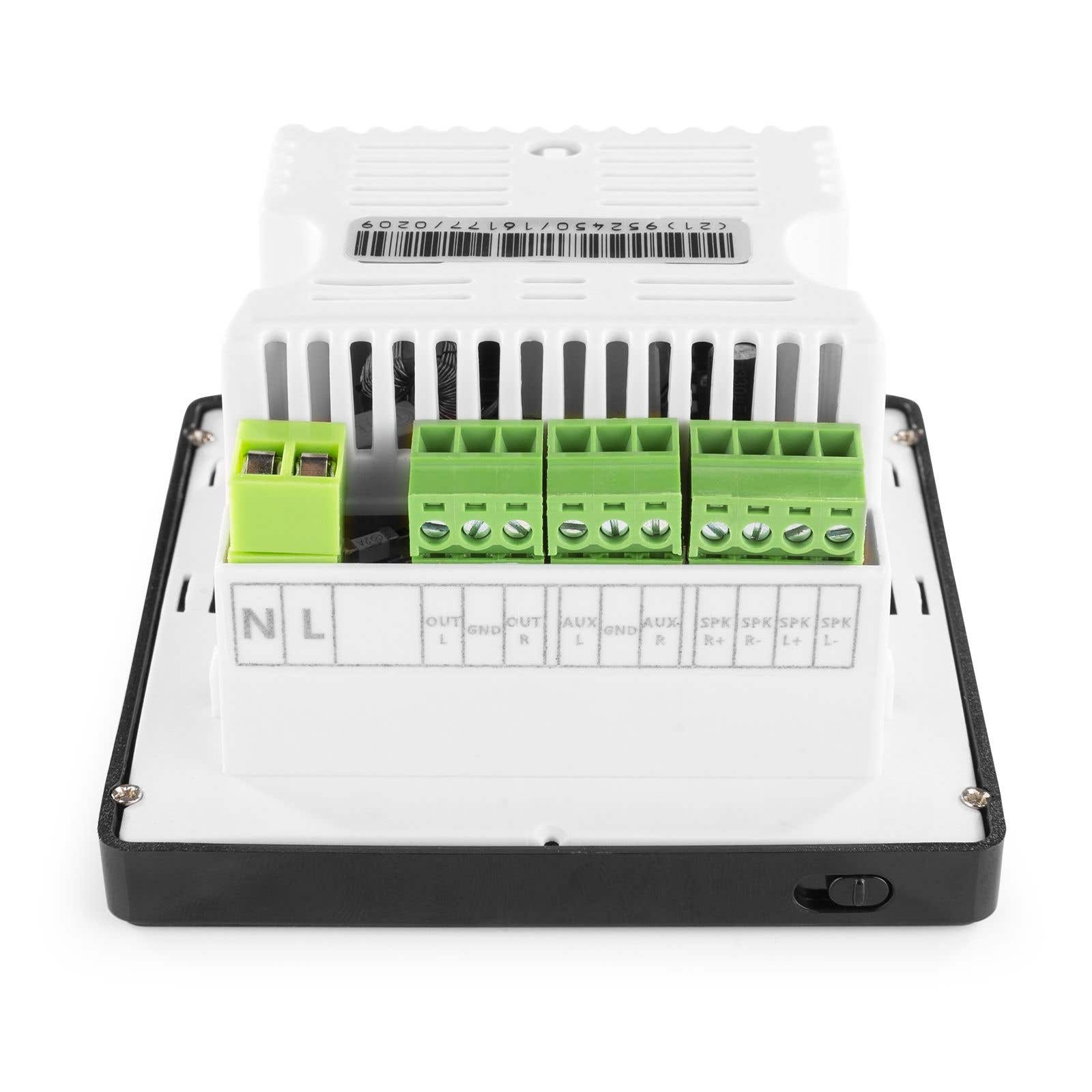 Un dispositivo electrónico blanco con conectores verdes, etiquetado con letras y símbolos, se encuentra sobre una base negra.