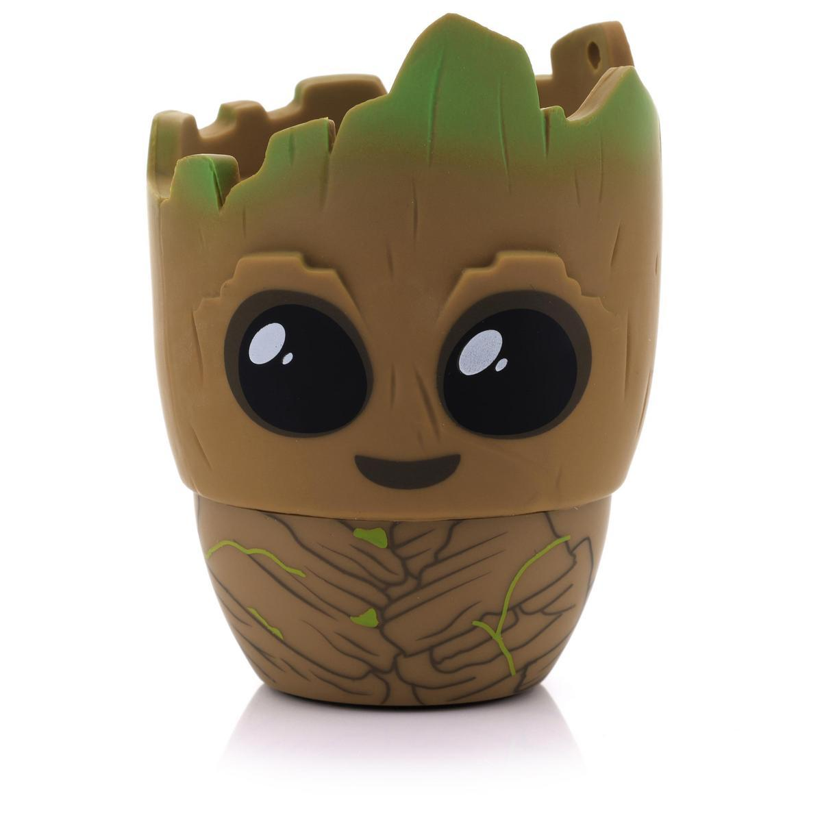 Un vaso a forma di Groot. Ha un corpo marrone, dettagli verdi e grandi occhi neri. Si trova su una superficie bianca.