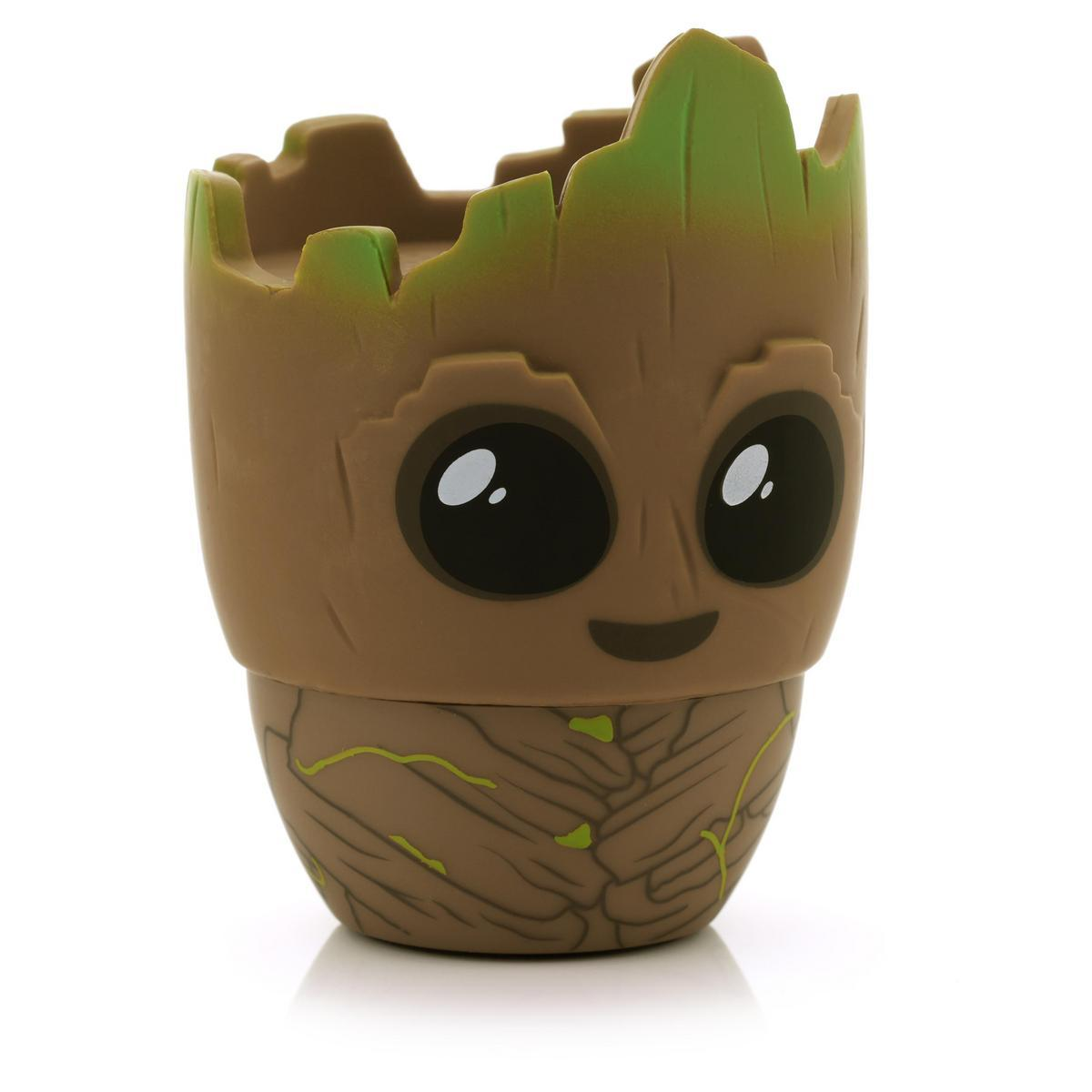 Un contenitore marrone a forma di Groot con una parte superiore verde a forma di foglia e grandi occhi neri. Ha un volto sorridente e una struttura in legno dettagliata.