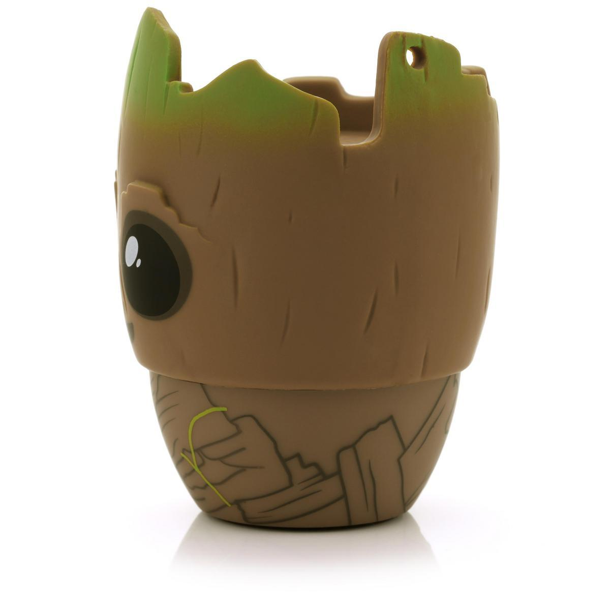 Una fioriera a forma di Groot, marrone con la parte superiore verde. Ha un occhio e una texture della corteccia dettagliata. Su sfondo bianco.