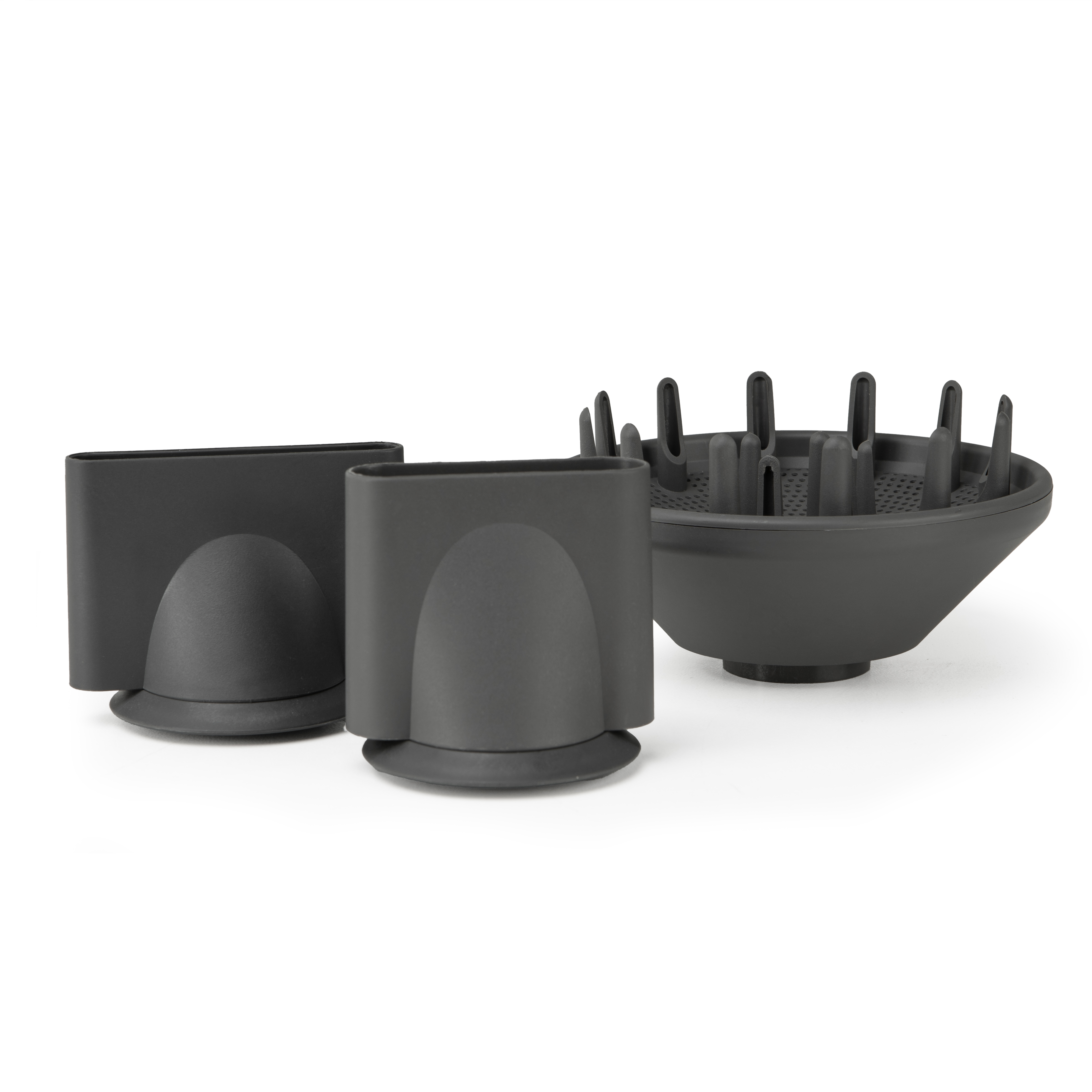 Tre accessori neri per asciugacapelli su sfondo bianco. Uno è un diffusore, due sono accessori per ugelli.