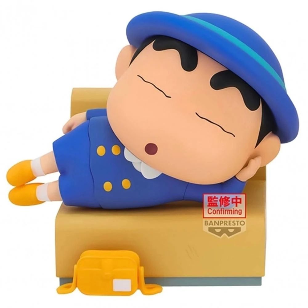 Una statuetta di un ragazzo dei cartoni animati in abito e cappello blu che dorme su un divano giallo. Una borsa gialla è vicino al divano.