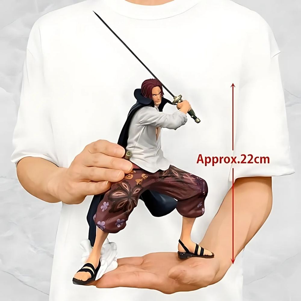 Una persona sostiene una figura de Shanks con una espada. La figura mide unos 22 cm. La persona lleva una camisa blanca.