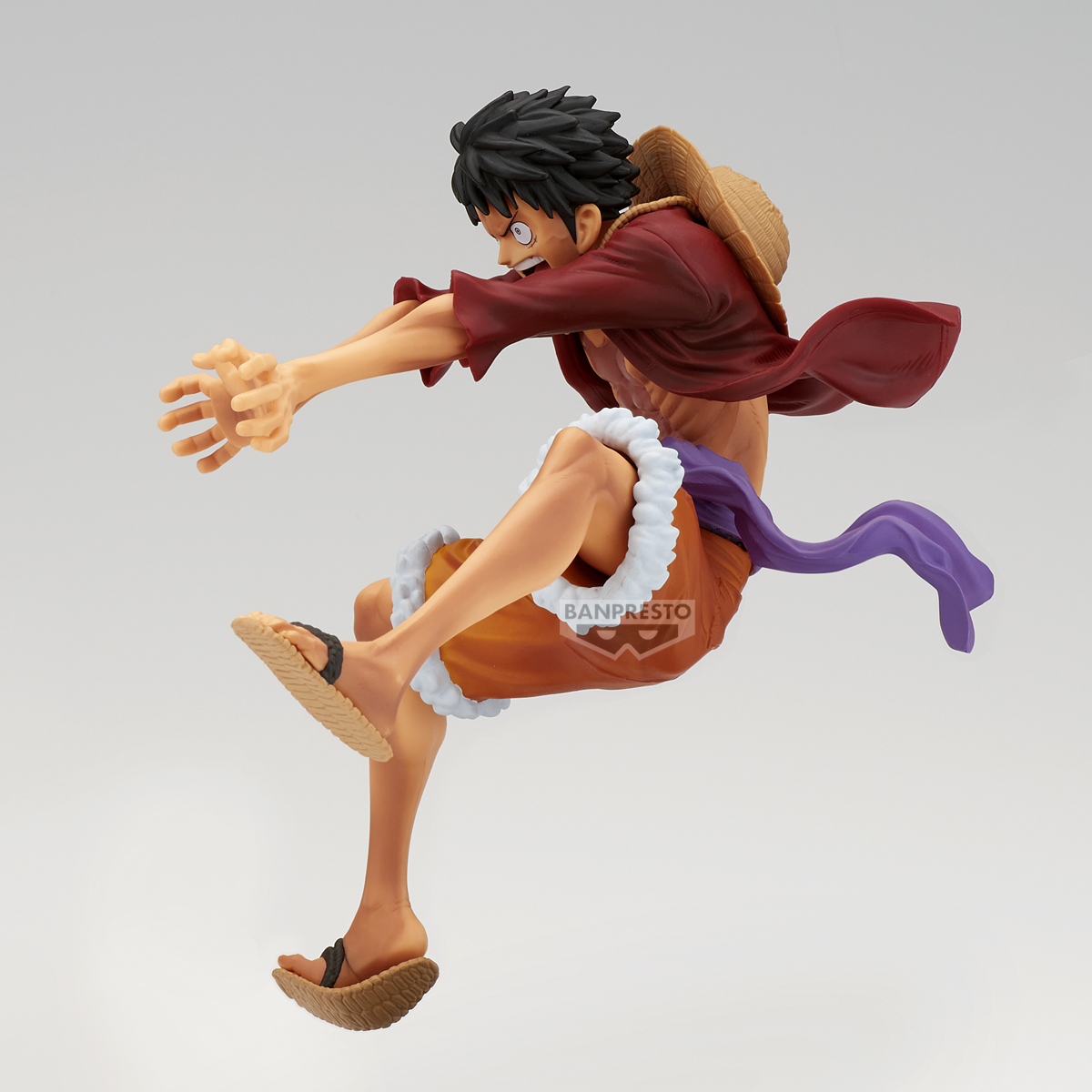 Una statuetta di Luffy a mezz'aria. Indossa una camicia rossa, pantaloncini arancioni e sandali. Sono presenti anche un cappello di paglia e una sciarpa viola.