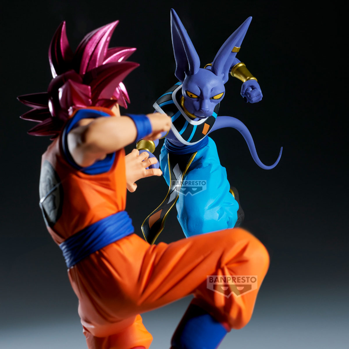 Figuren von Goku und Beerus in Actionposen. Goku in orangefarbenem Gi mit stacheligem, pinkfarbenem Haar. Beerus, lila mit großen Ohren.