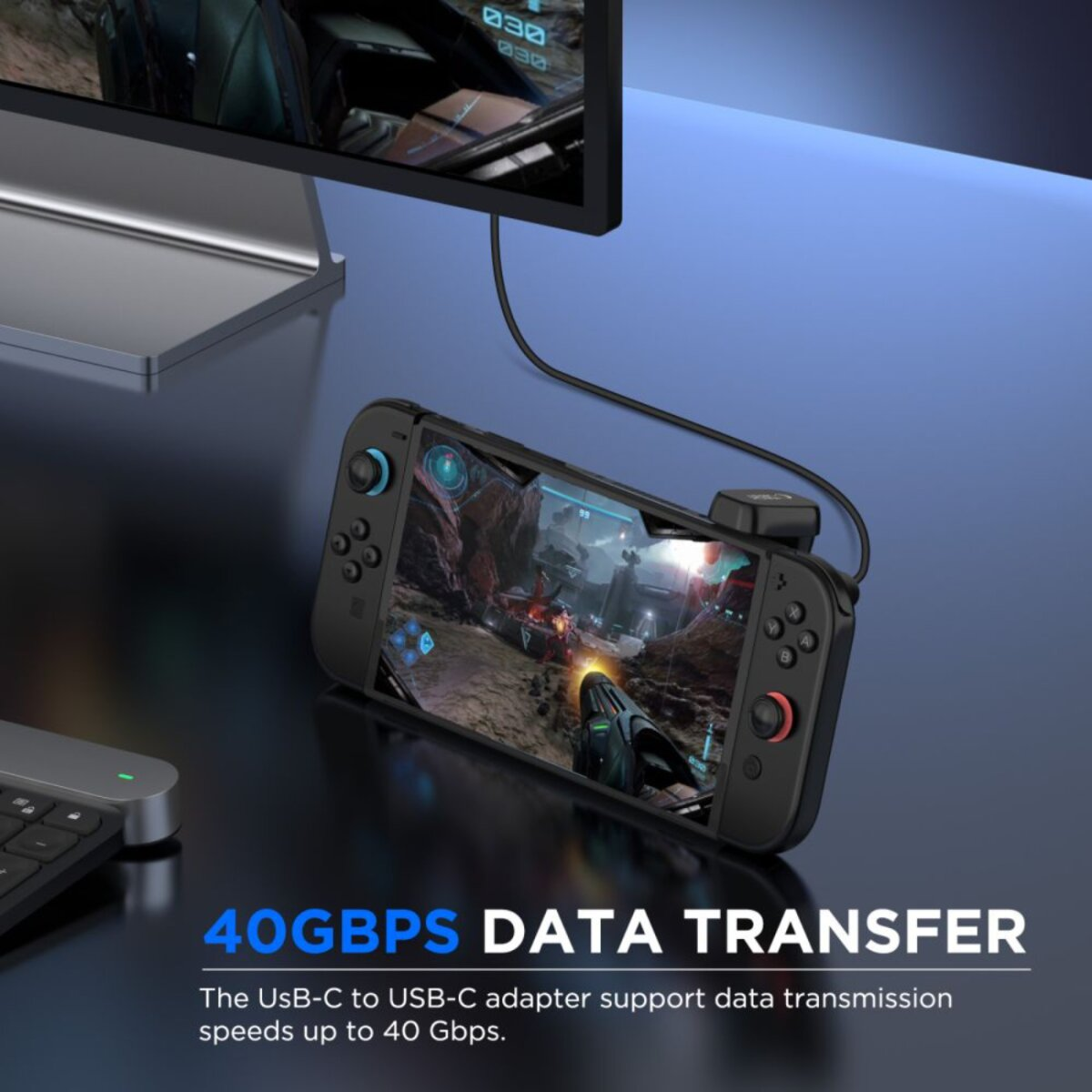 Een handheld console aangesloten op een monitor. Het scherm toont een game. De tekst onderaan luidt '40GBPS DATA TRANSFER'.