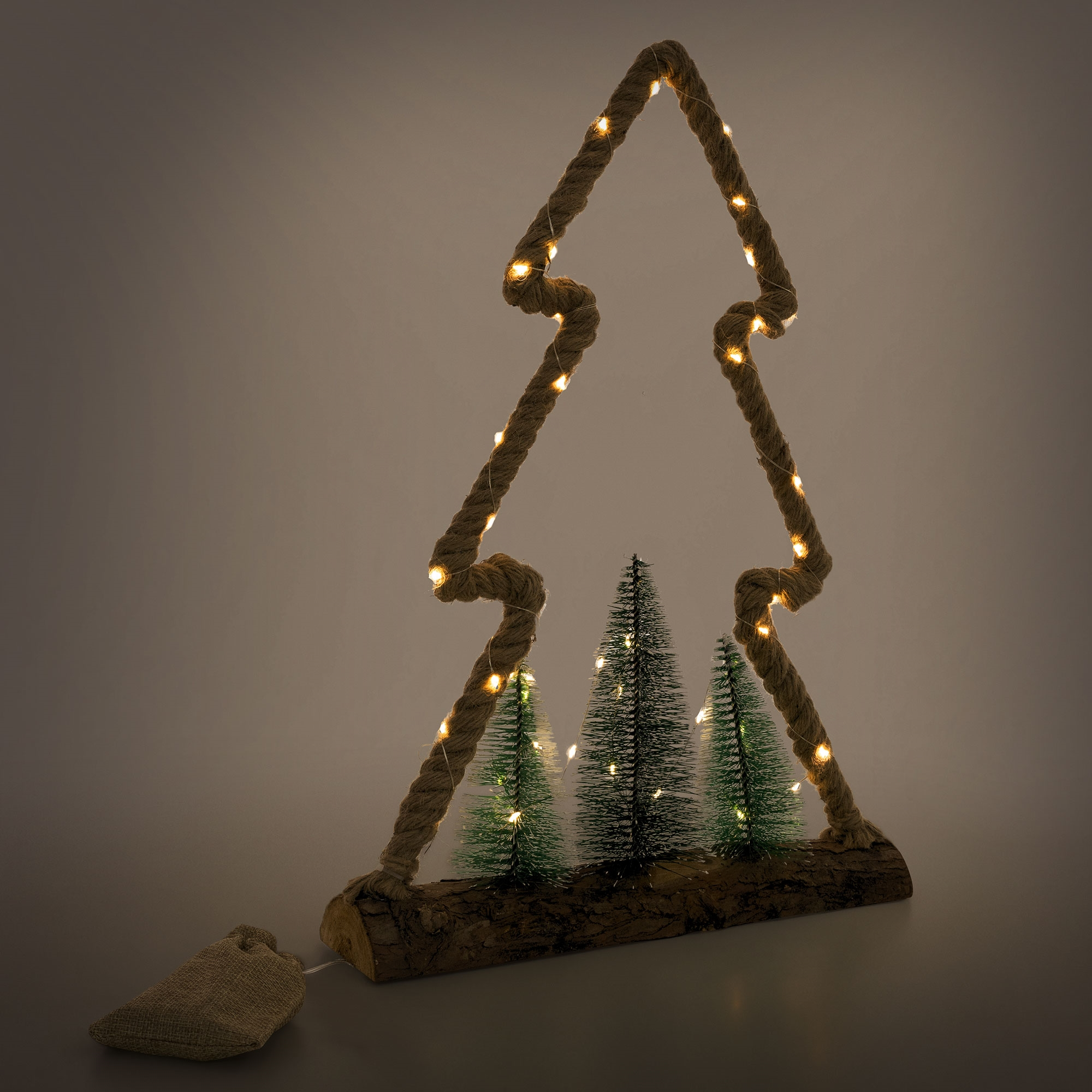 Weihnachtsbaumdekoration. Seilbaum mit Lichtern, kleine Tannen und ein Sack.