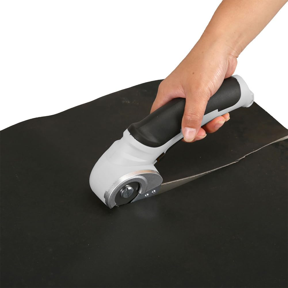 Eine Hand hält einen grau-schwarzen Rollschneider und schneidet eine schwarze Gummiplatte. Die Klinge ist silber. Der Hintergrund ist weiß.