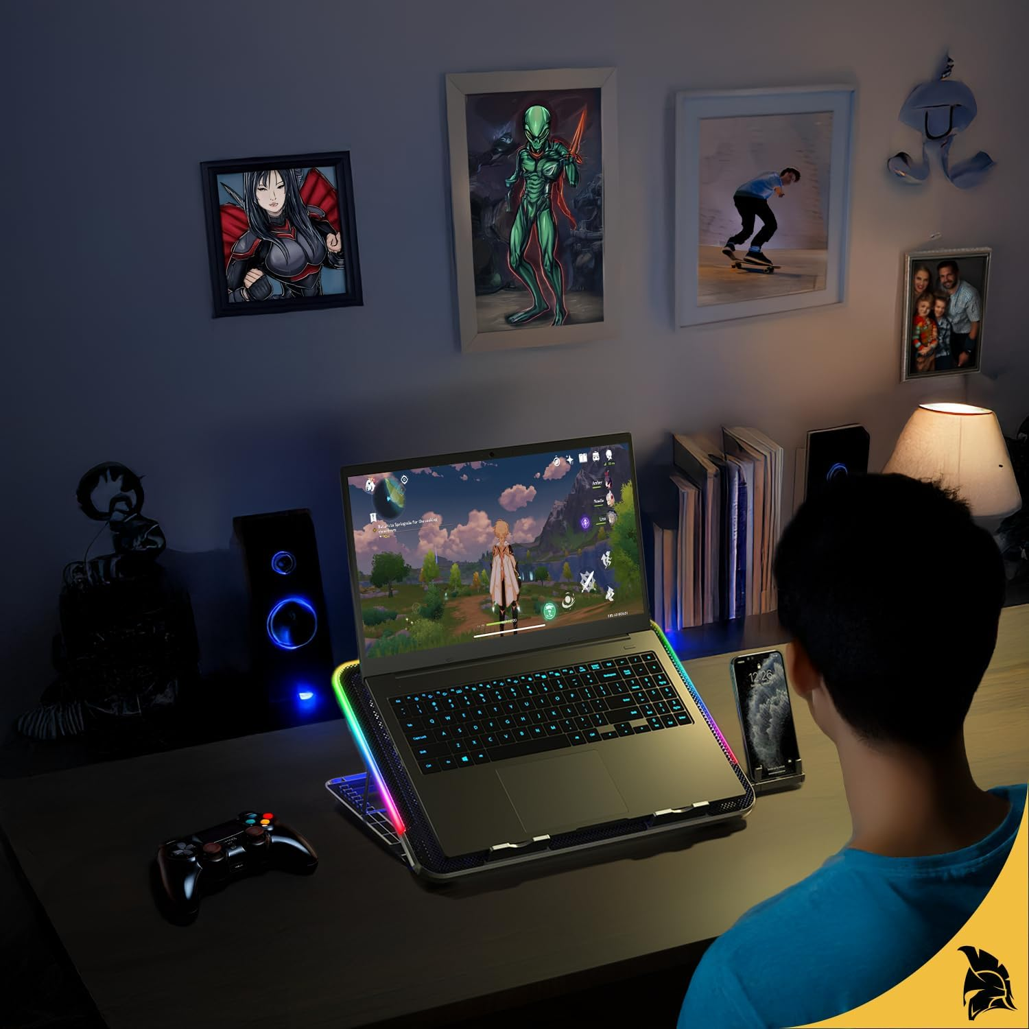 Eine Person spielt auf einem Laptop. Auf dem Schreibtisch befinden sich Lautsprecher, gerahmte Bilder, ein Telefon und ein Controller.