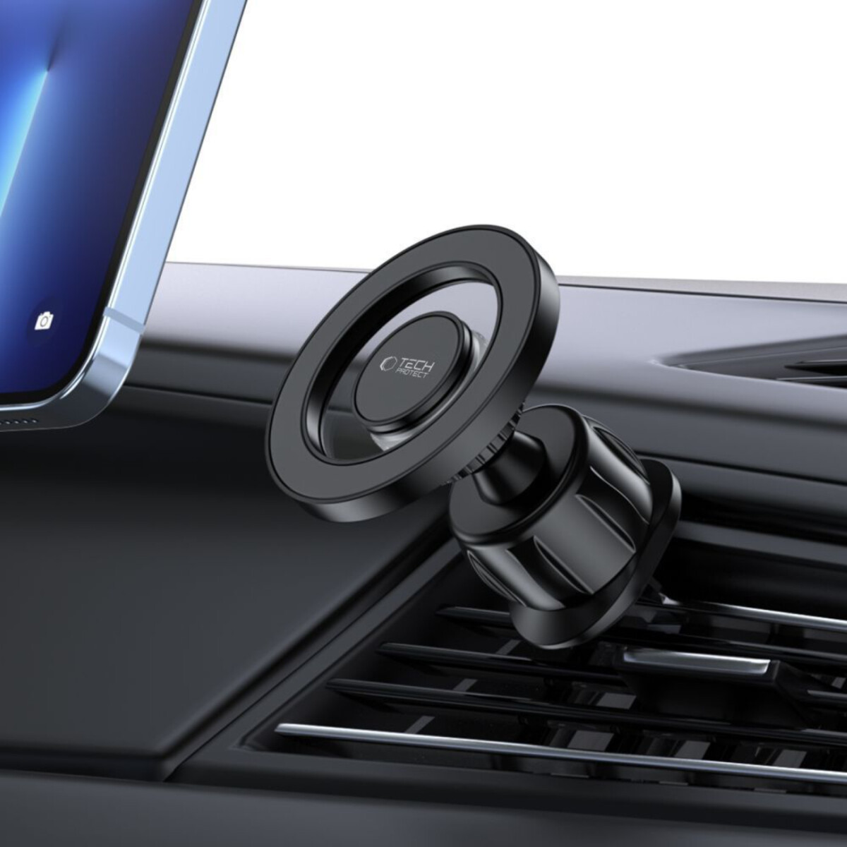 Ein schwarzer Autotelefonhalter ist am Armaturenbrett-Lüftungsschlitz befestigt und hält ein Tablet. Der Halter hat ein Ringdesign mit Markenlogo.