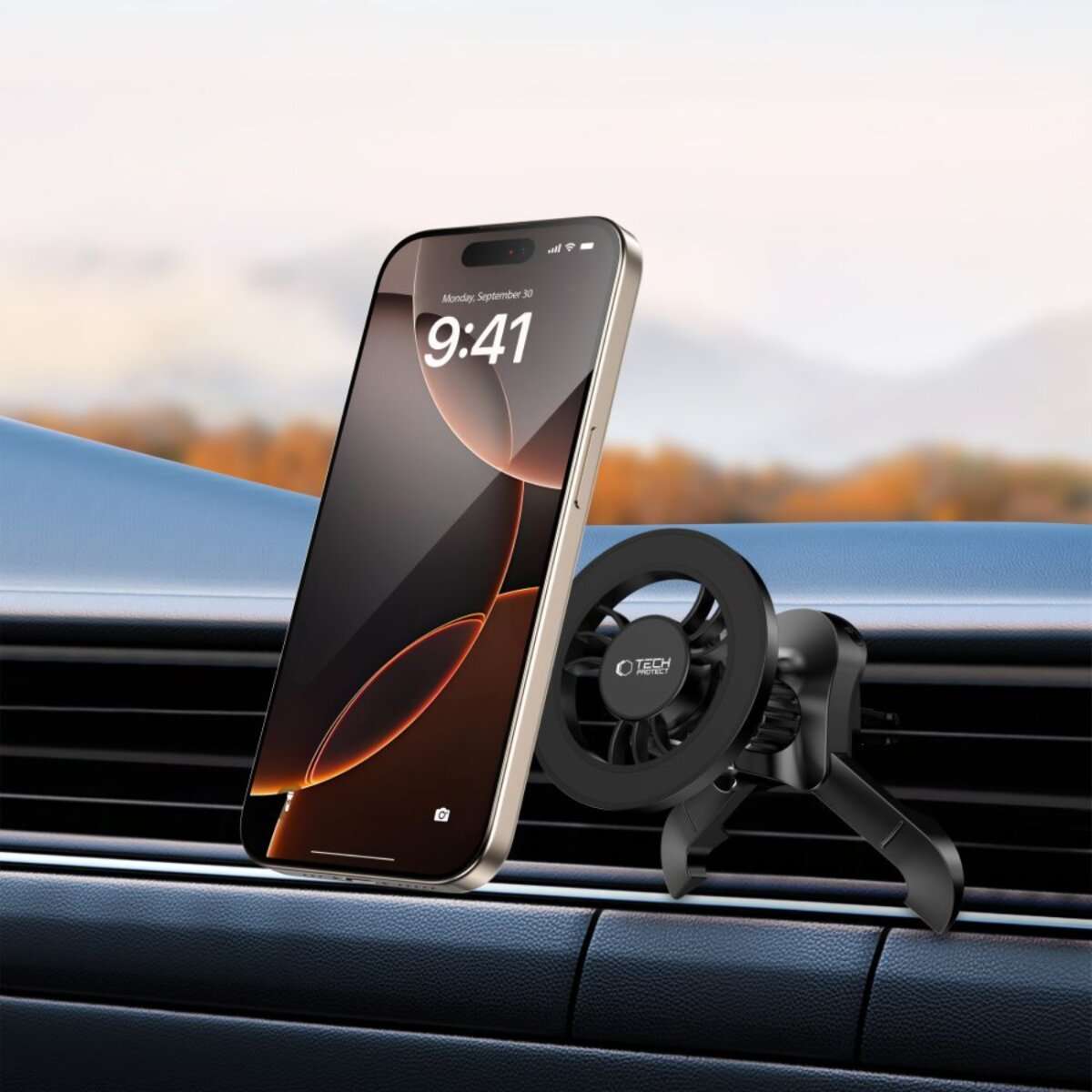 Ein Telefon ist auf einer schwarzen Lüftungshalterung befestigt. Das Telefon zeigt die Uhrzeit 9:41 an. Der Hintergrund zeigt eine unscharfe Herbstszene.