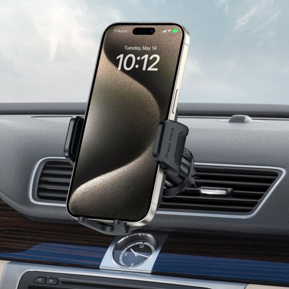 Ein Smartphone ist im Auto montiert. Das Telefon zeigt die Uhrzeit. Das Telefon befindet sich in einer Lüftungshalterung. Das Armaturenbrett ist sichtbar.