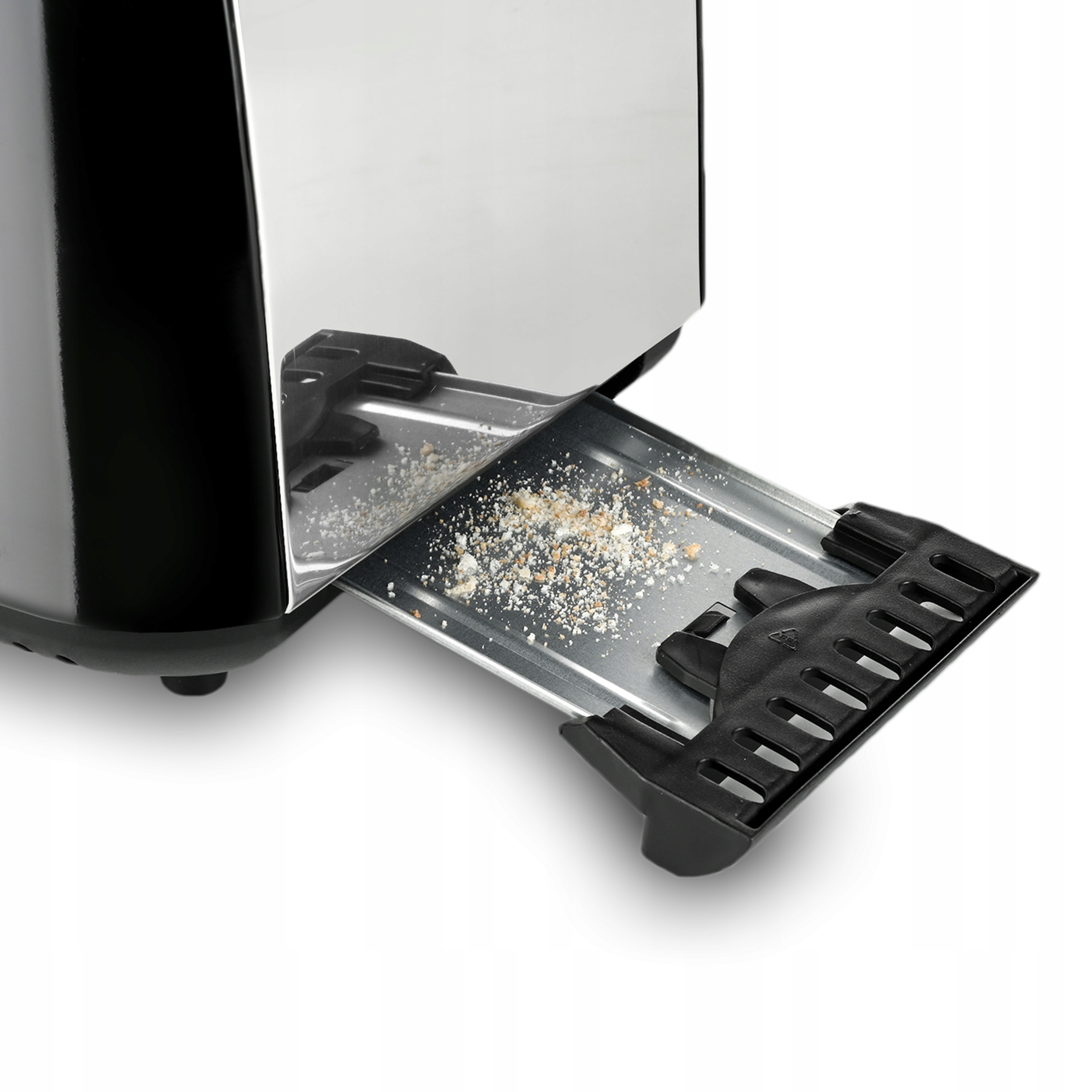 Zbliżenie na toster z wysuniętą tacą na okruchy, wypełnioną okruchami. Toster jest czarny i srebrny.