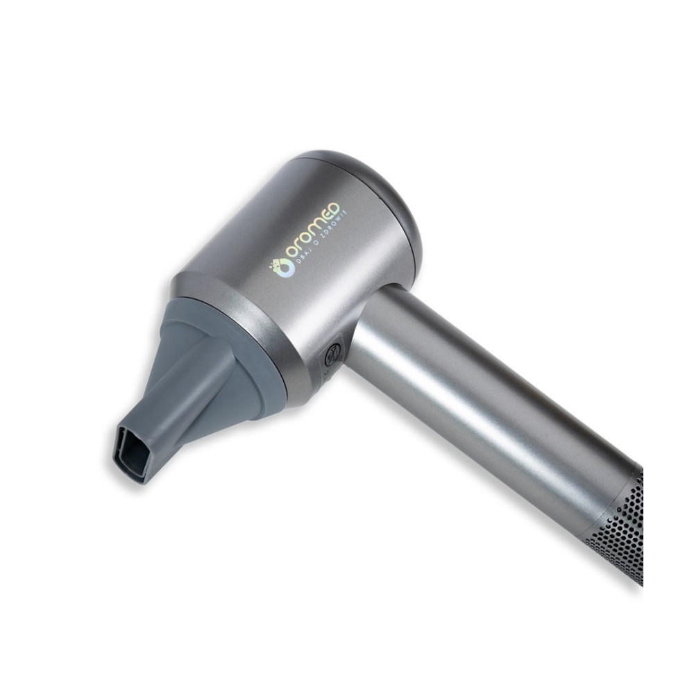 Srebrna suszarka do włosów z marką 'Oromed'. Ma szarą dyszę i uchwyt, na białym tle.