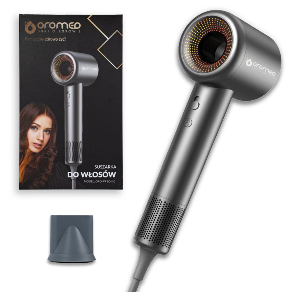 Szara suszarka do włosów z czarnym pudełkiem po lewej stronie. Suszarka ma okrągłą głowicę z pomarańczowymi światłami i uchwytem.