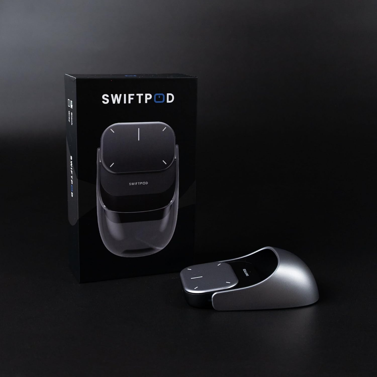Ein Swiftpod-Gerät und eine Box stehen auf einer schwarzen Oberfläche. Das Gerät ist silber und schwarz, die Box im Hintergrund.