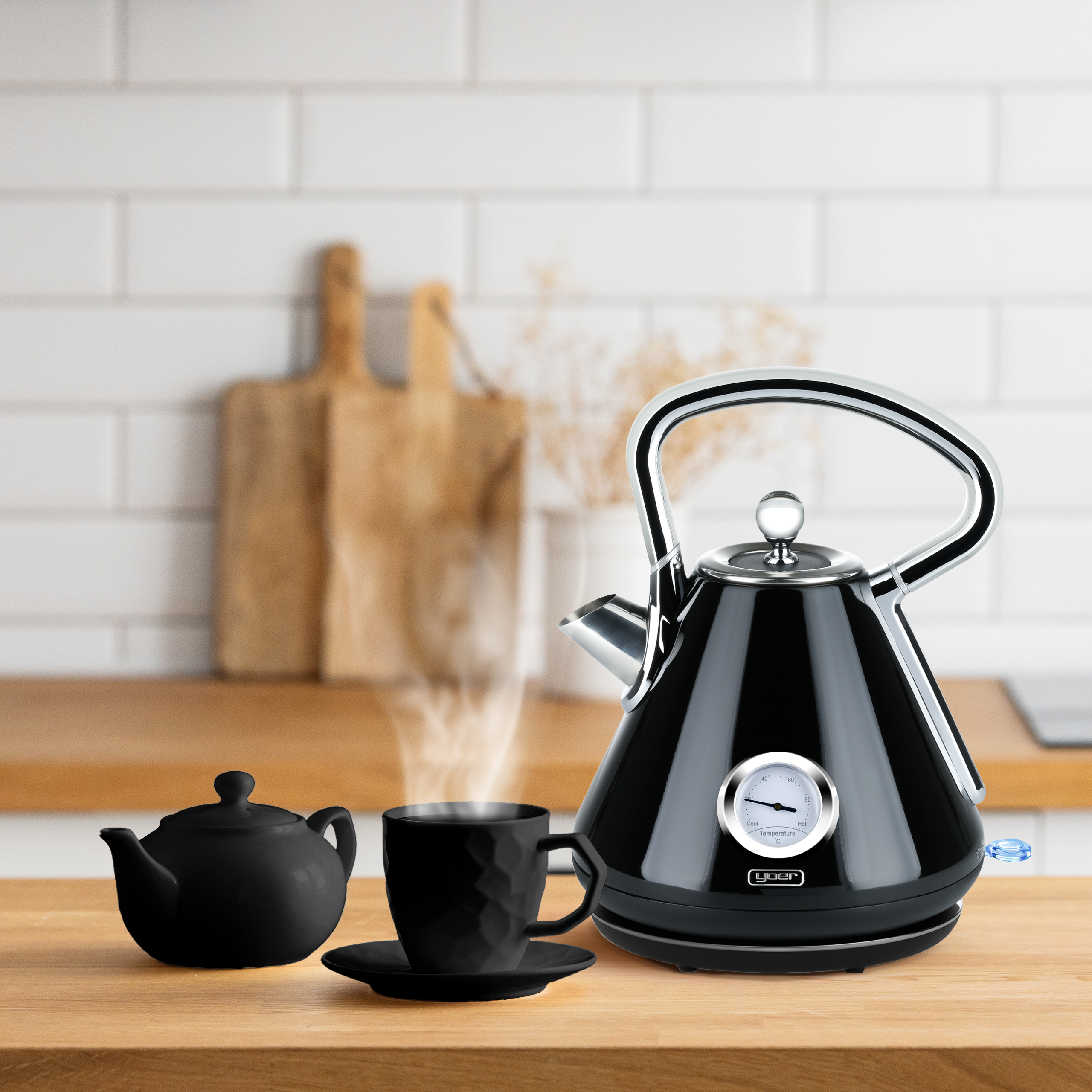Czarny czajnik, czajniczek i filiżanka na drewnianej powierzchni. Para unosi się z filiżanki.