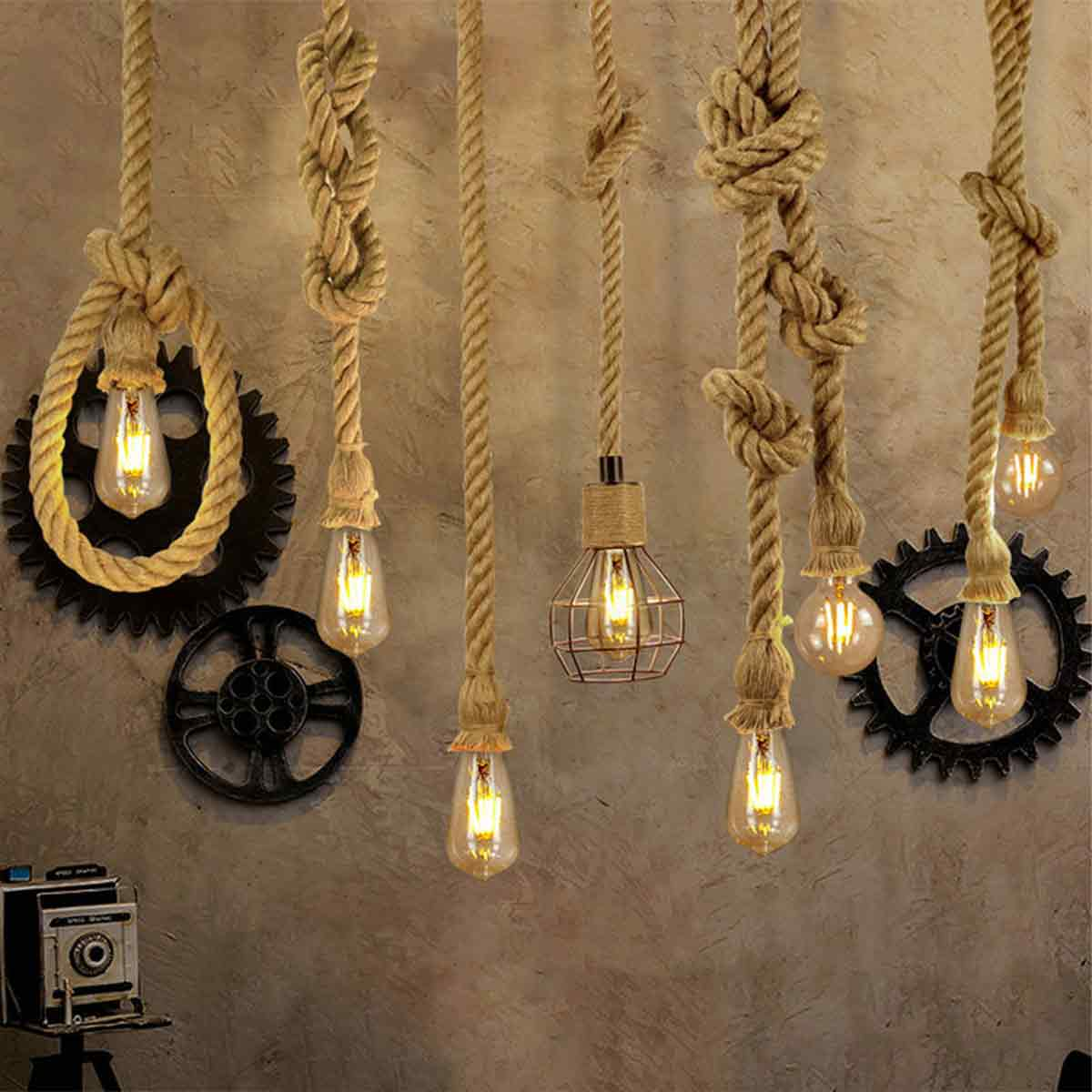 Mehrere Hängelampen mit Edison-Glühbirnen und Seilen. Zahnrad- und Raddekorationen sowie eine Vintage-Kamera sind ebenfalls vorhanden. Der Hintergrund ist eine strukturierte Wand.