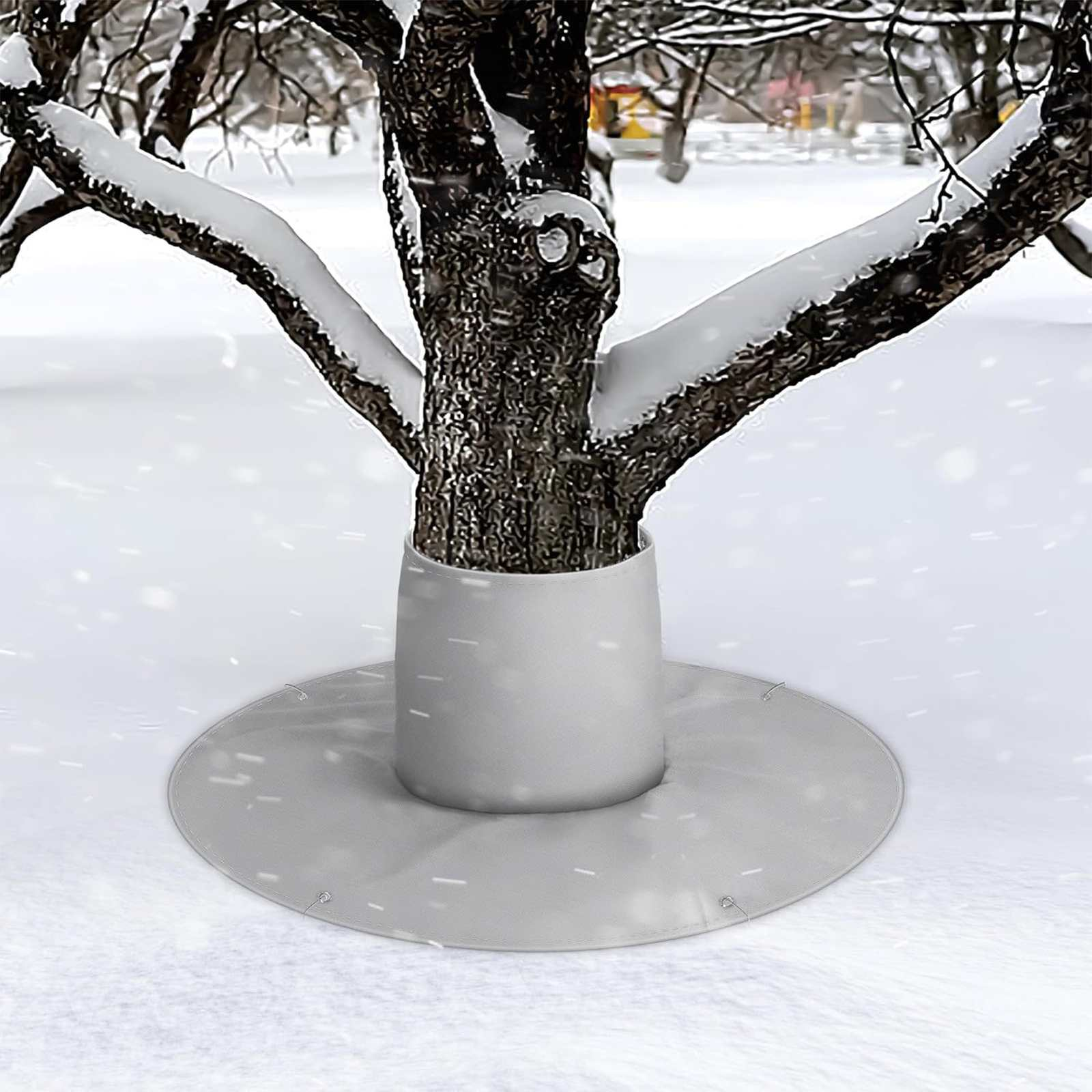 Ein Baum in einer schneebedeckten Landschaft. Der Baumstamm hat einen weißen Sockel und eine kreisförmige Abdeckung. Schnee liegt auf den Ästen.