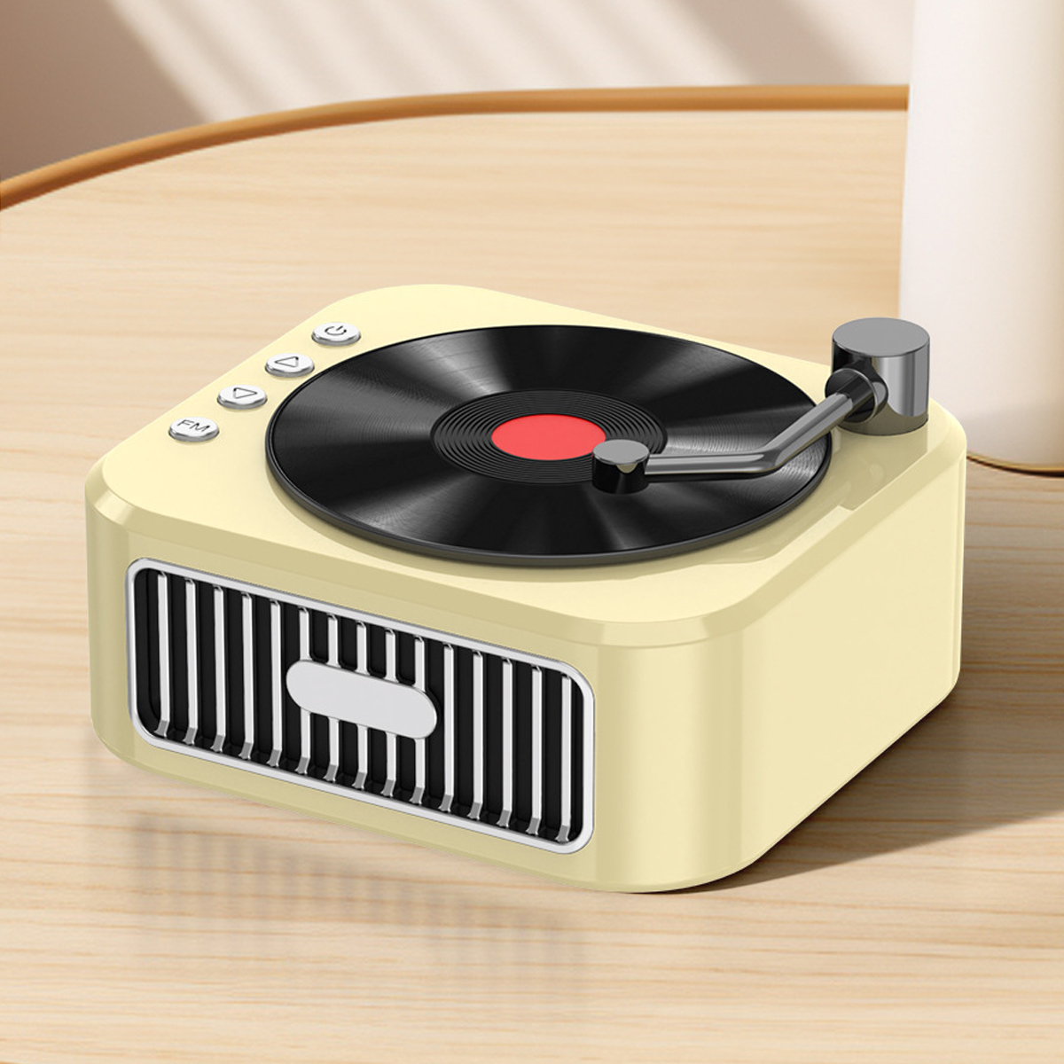 Ein cremefarbener Retro-Plattenspieler mit schwarzer Schallplatte und roter Mitte auf einem Holztisch. Knöpfe sind sichtbar.
