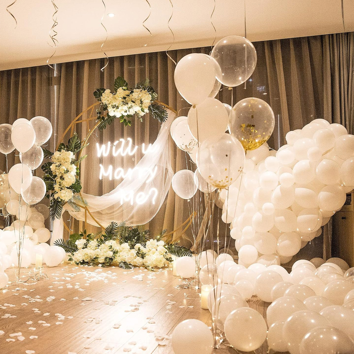 Eine Szene mit Heiratsantrag, Ballons, Blumen und einem Leuchtschild mit der Aufschrift 'Willst du mich heiraten?'.