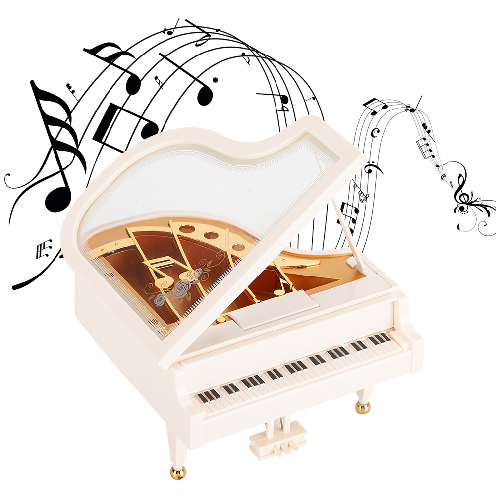 Eine weiße Klavier-Spieluhr mit schwarzen Noten. Der Klavierdeckel ist geöffnet und zeigt goldfarbene Elemente.