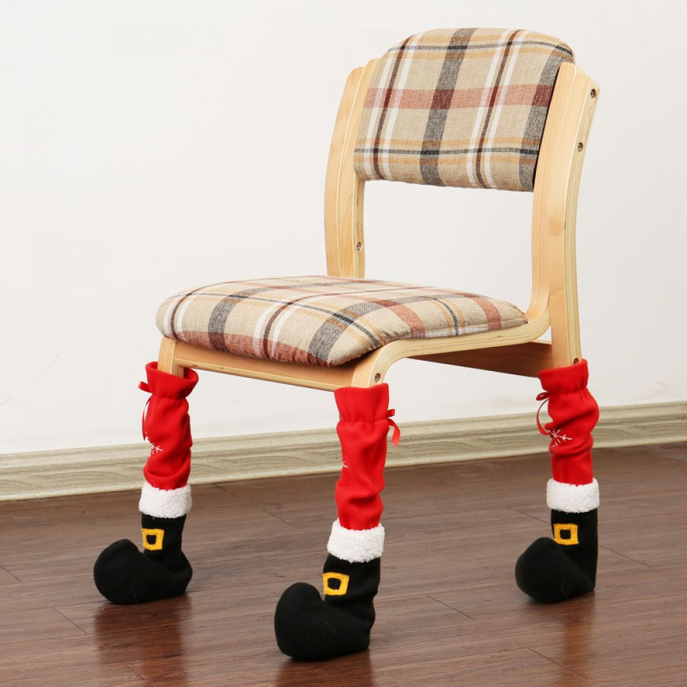 Ein Stuhl mit Santa-Beinen. Der Stuhl hat eine karierte Sitzfläche und Rückenlehne. Die Beine sind mit roten Socken mit schwarzen Stiefeln bedeckt.