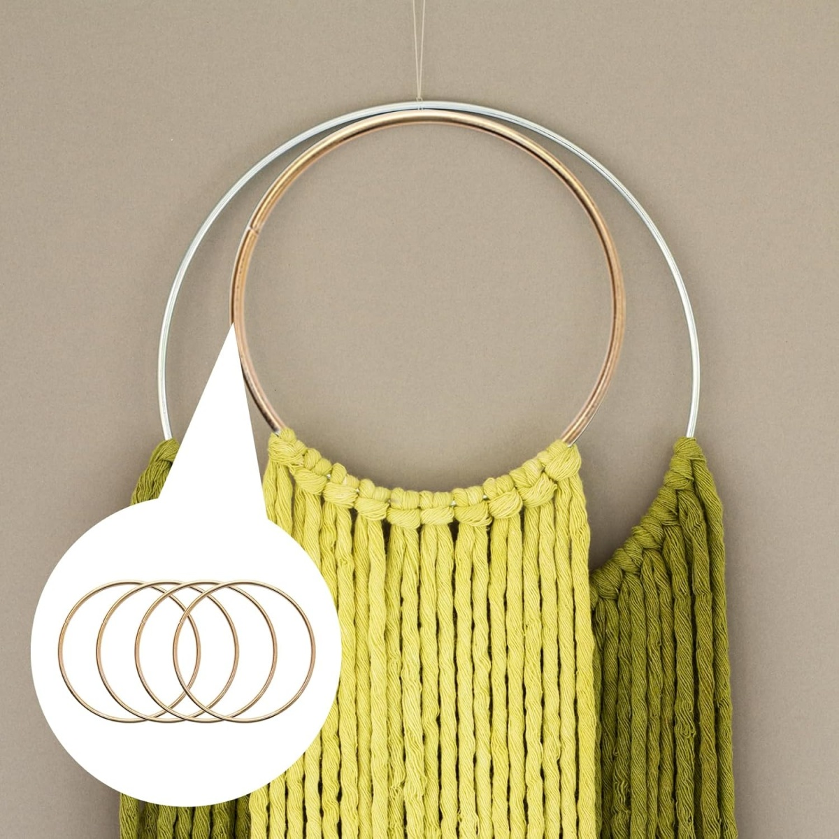 Makramee-Wandbehang mit zwei Ringen und grüner und gelber Wolle. Ein Kreis zeigt vier goldene Ringe.