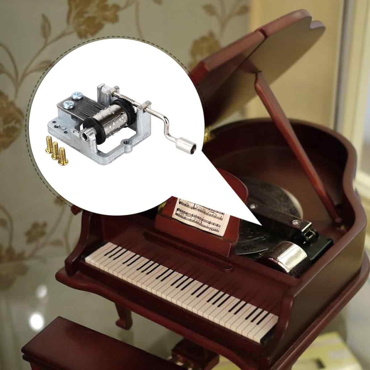 Ein Miniatur-Klavier aus Holz mit einem kurbelbetriebenen Spieluhr-Mechanismus. Das Klavier ist braun mit weißen und schwarzen Tasten. Es gibt ein Notenblatt.