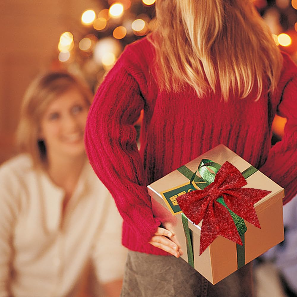 Eine Person versteckt eine Geschenkbox hinter dem Rücken. Auf dem Geschenk befindet sich eine rote Schleife. Eine andere Person lächelt im Hintergrund.