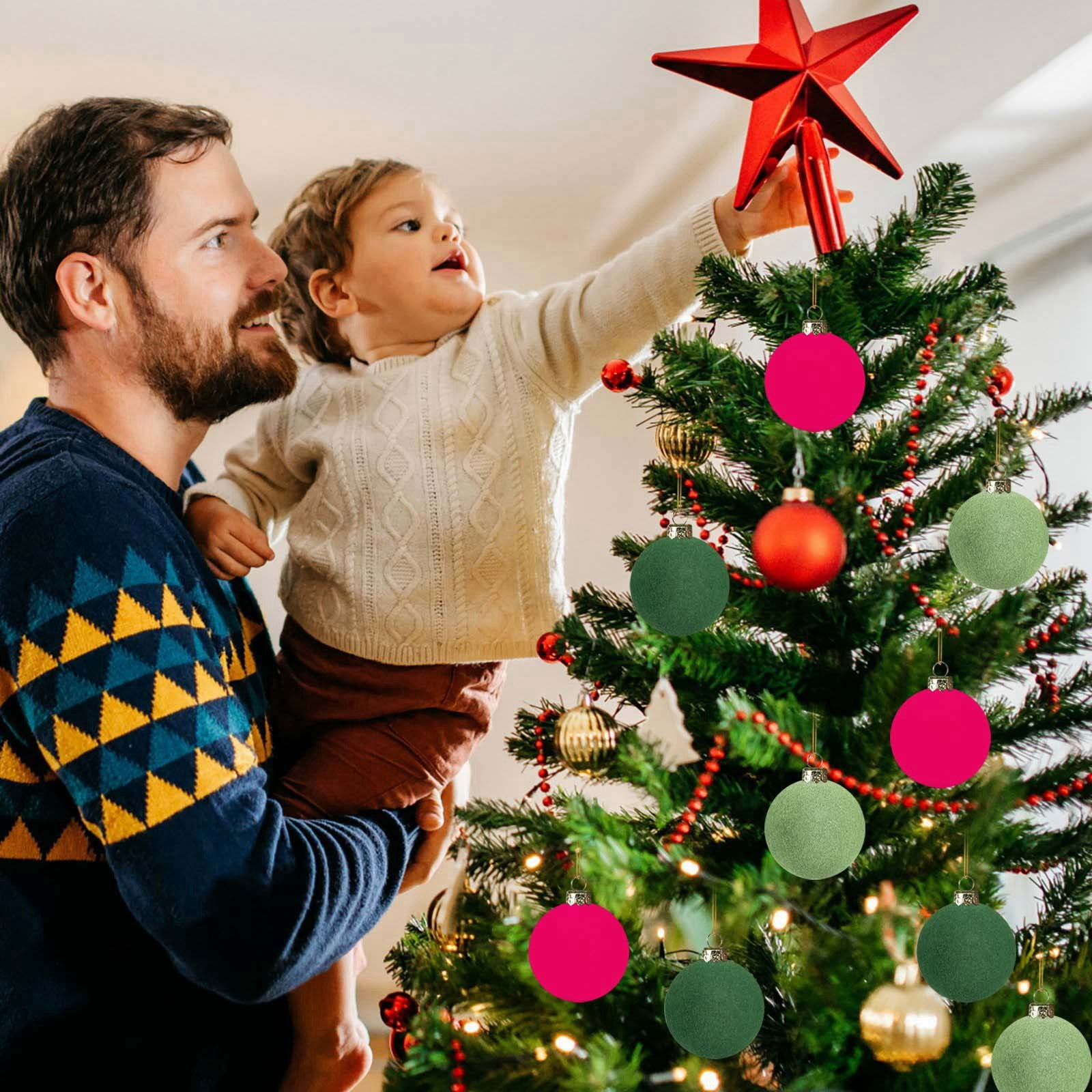 Ein Vater hält ein Kind, das nach einem Stern auf einem geschmückten Weihnachtsbaum greift.