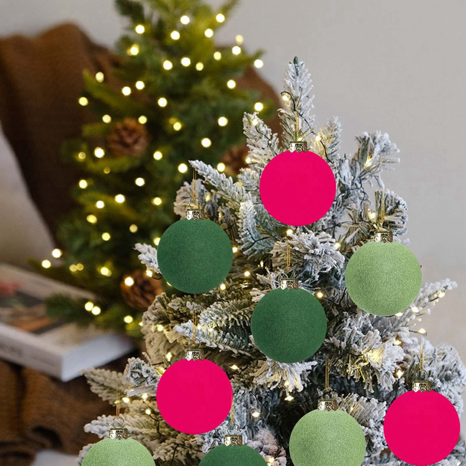 Weihnachtsbaum mit Ornamenten. Pinke und grüne Kugeln hängen an den Ästen. Lichter sind im Hintergrund an.