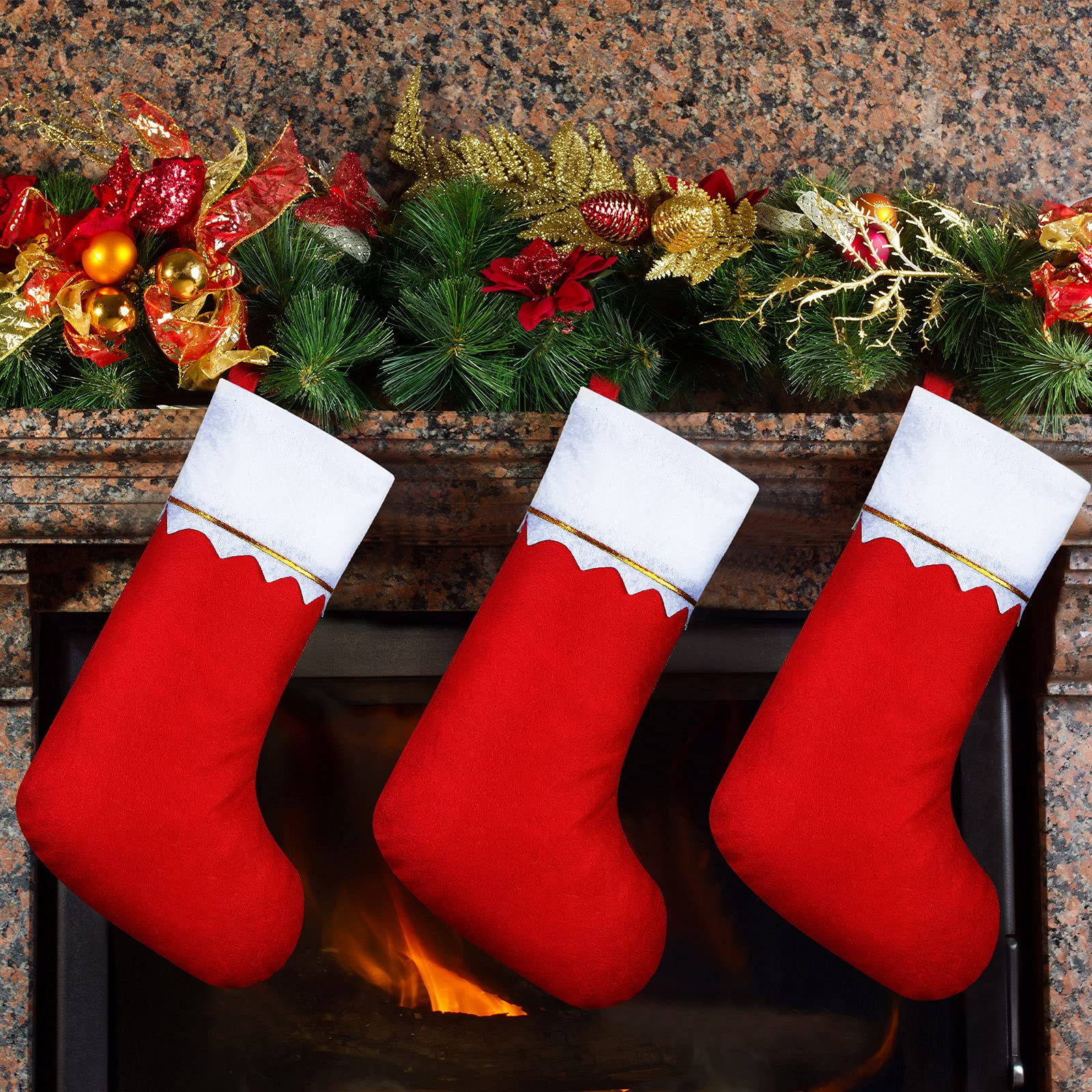 Drei rote Weihnachtsstrümpfe hängen an einem Kamin mit einer Girlande darüber, Feuer im Herd.