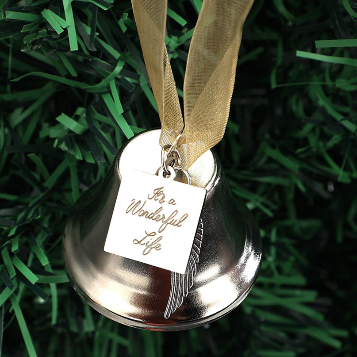 Silberner Glockenornament mit goldenem Band, Anhänger mit 'It's a Wonderful Life' und Federdesign.