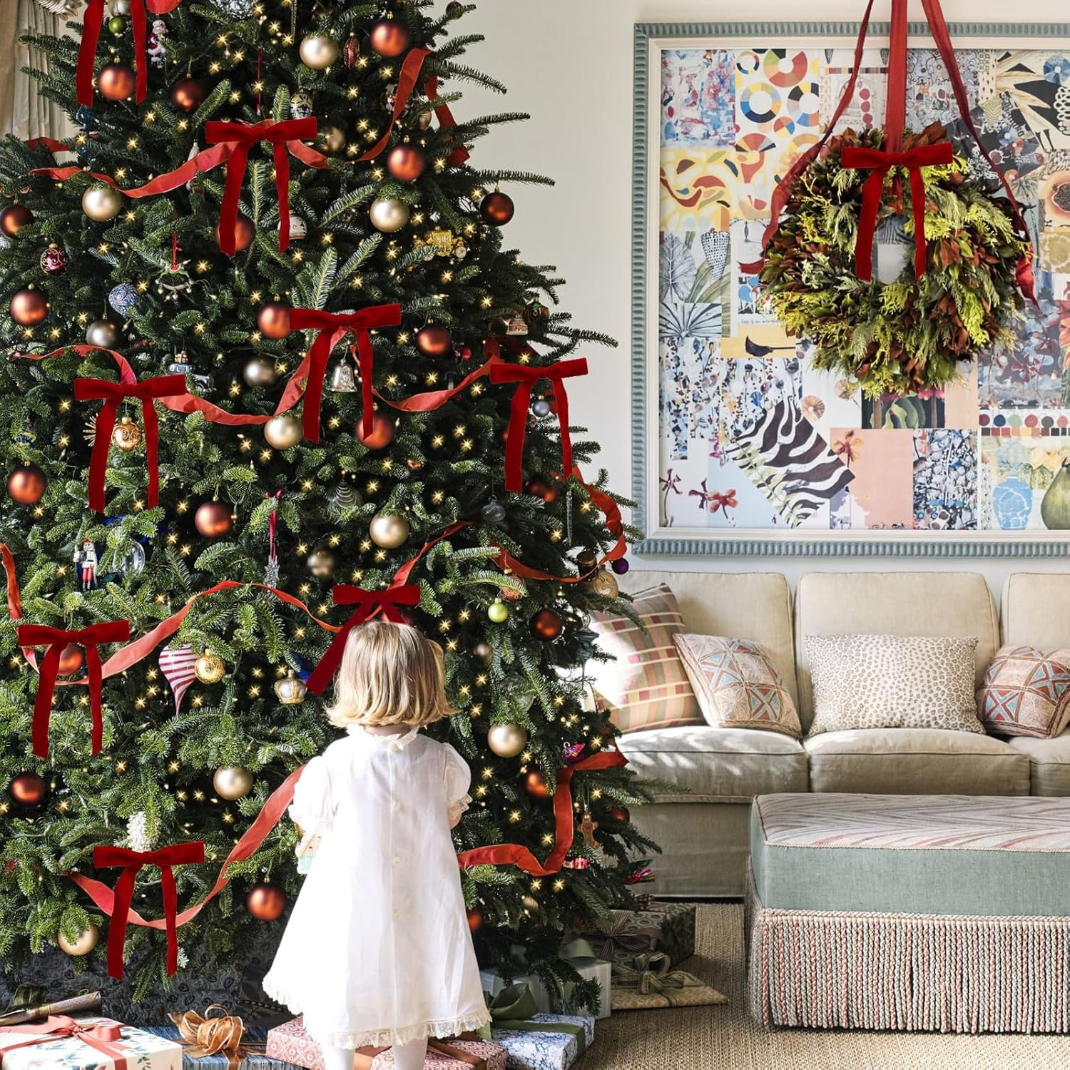Ein Mädchen in weißem Kleid betrachtet einen geschmückten Weihnachtsbaum mit roten Schleifen und Ornamenten. Ein Kranz hängt an der Wand.