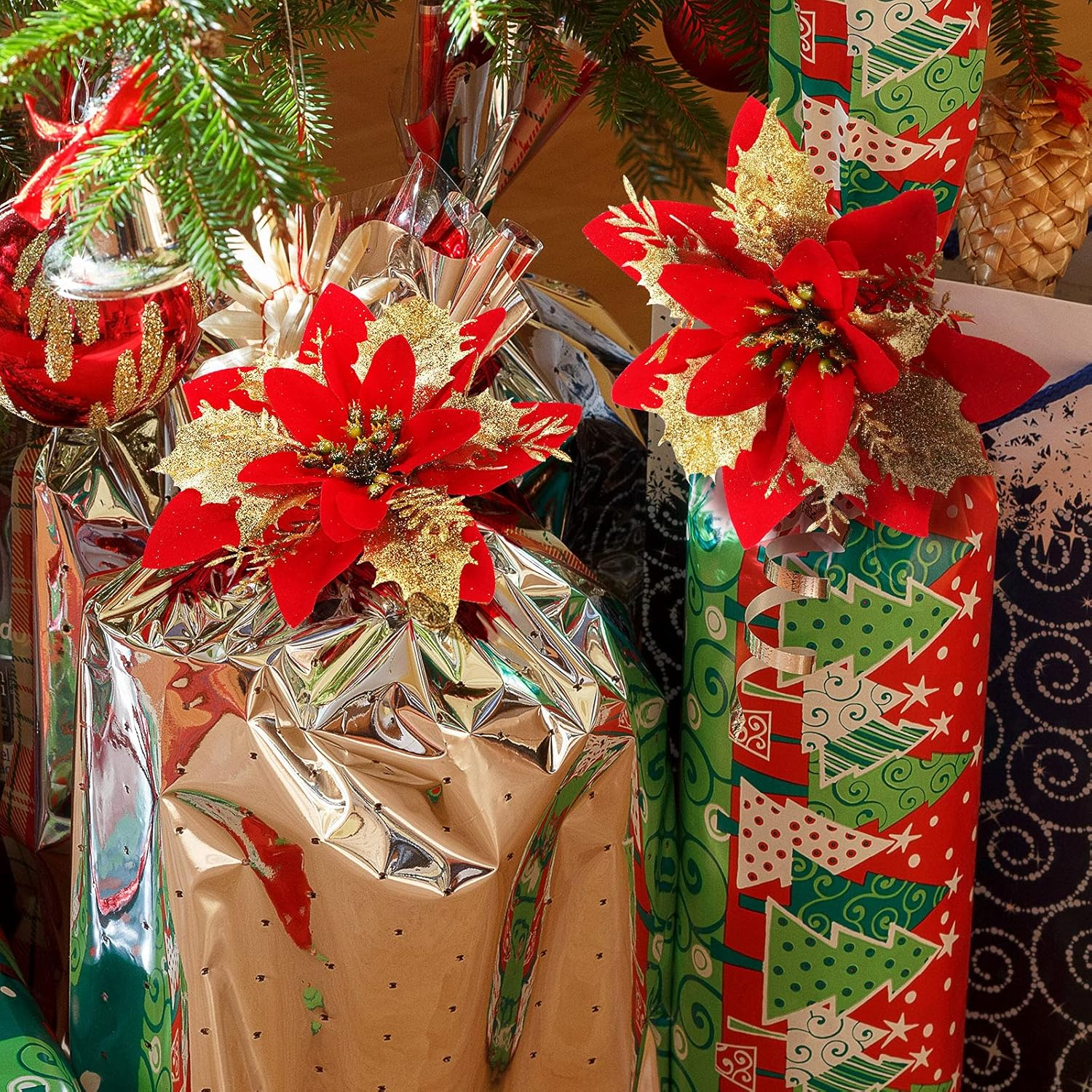 Weihnachtsgeschenke in glänzendem Papier verpackt, mit roten Weihnachtssternen und Ornamenten unter einem Weihnachtsbaum. Festliche Szene.