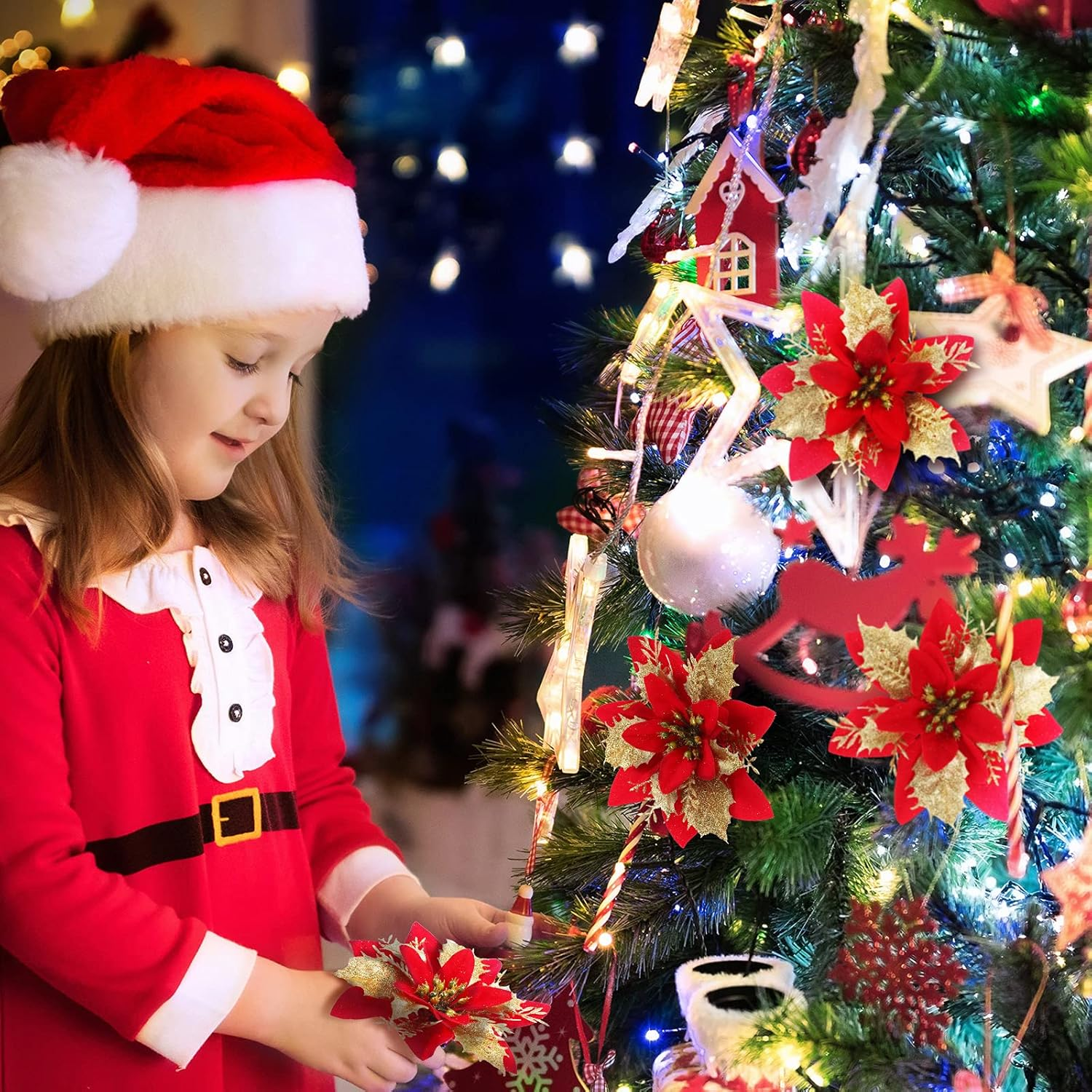 Ein Mädchen in einem Weihnachtsmann-Anzug schmückt einen Weihnachtsbaum mit Ornamenten. Der Baum ist beleuchtet und mit Blumen geschmückt.