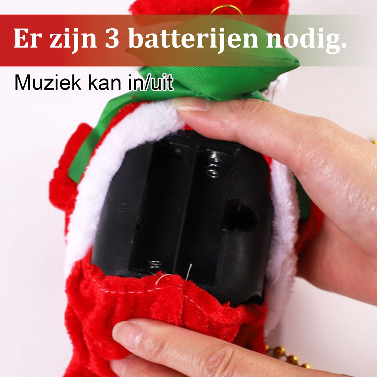 Eine Hand hält ein Weihnachtsmann-Spielzeug und zeigt das Batteriefach. Das Spielzeug ist rot, weiß und grün. Der Text oben lautet: '3 Batterien benötigt'.