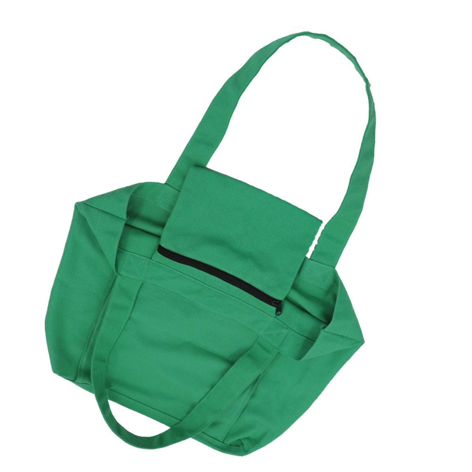 Eine grüne Canvas-Tragetasche mit einem schwarzen Reißverschluss an einer kleinen Tasche und einem langen Griff auf weißem Hintergrund.
