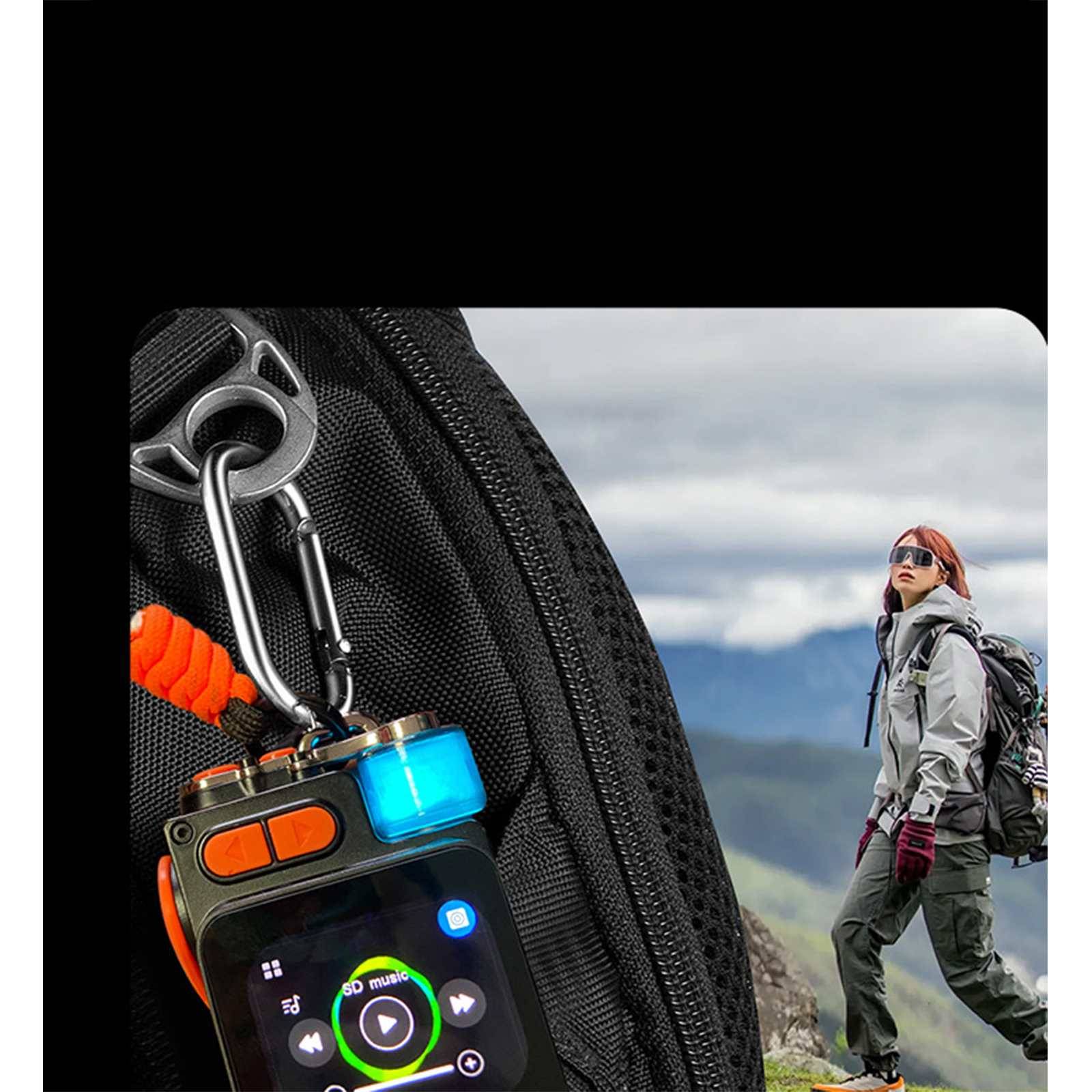Eine Wanderin mit Sonnenbrille und Rucksack steht auf einem Berg. Ein Gerät mit Bildschirm ist an einem Rucksackriemen befestigt.