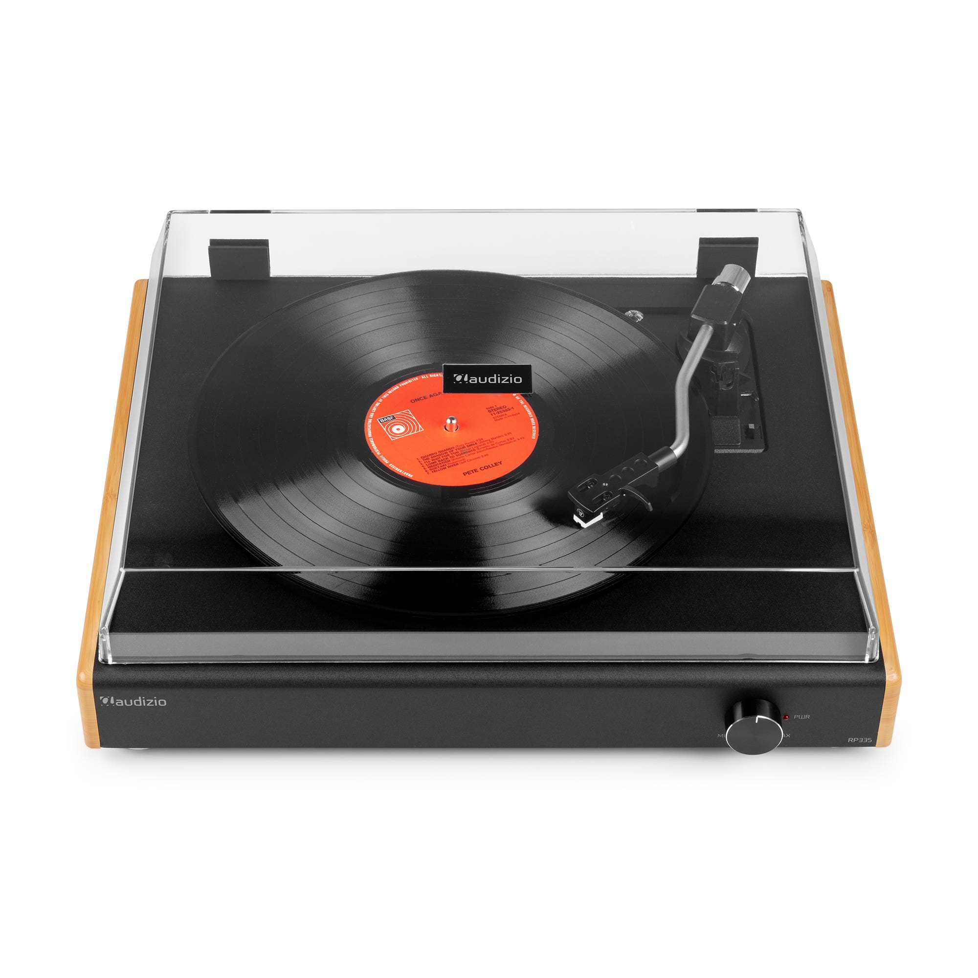 Un tocadiscos con un disco negro reproduciéndose. El tocadiscos es negro con laterales de madera y una cubierta transparente.