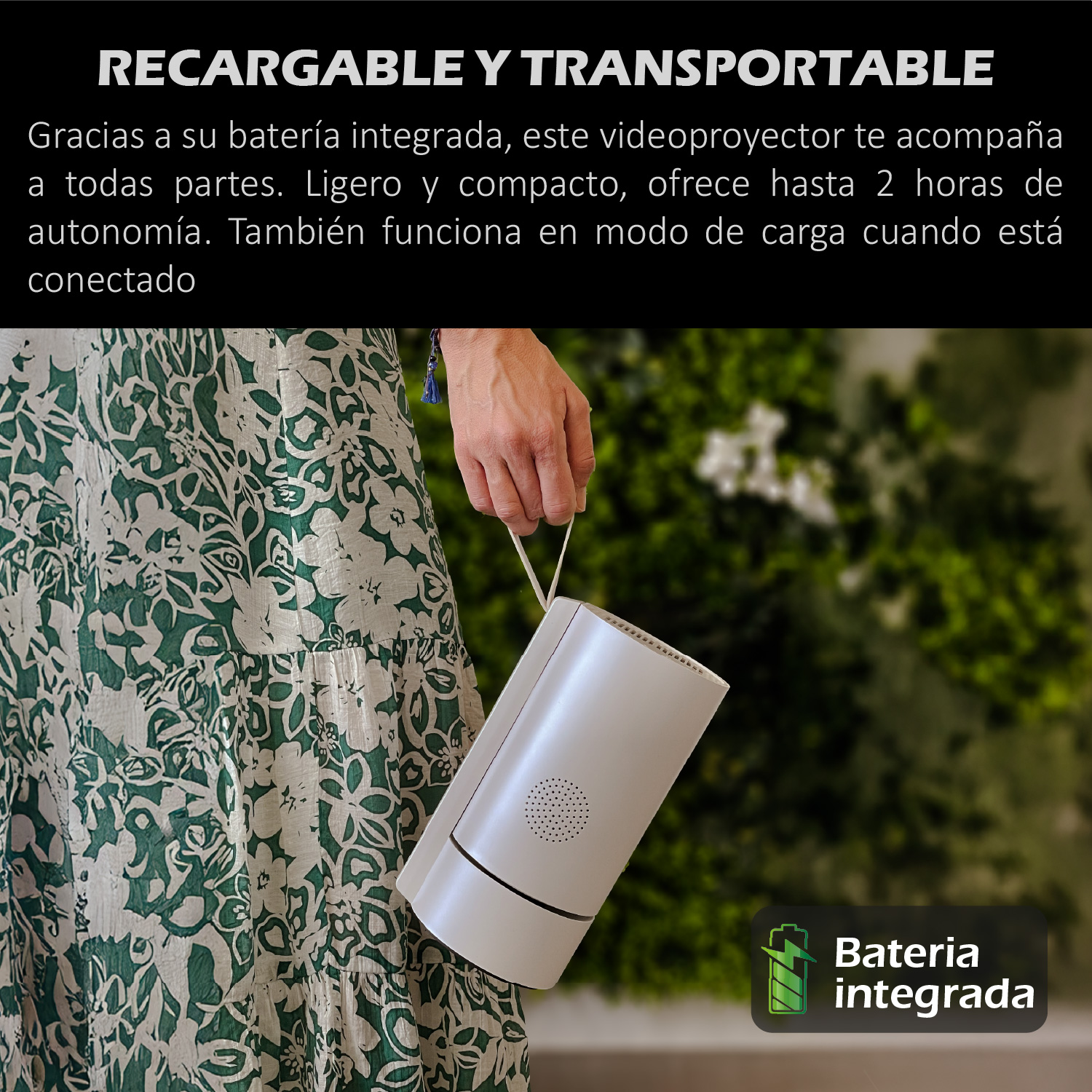 Una persona sostiene un proyector portátil blanco. La persona lleva un vestido floral verde. El fondo es follaje verde borroso.