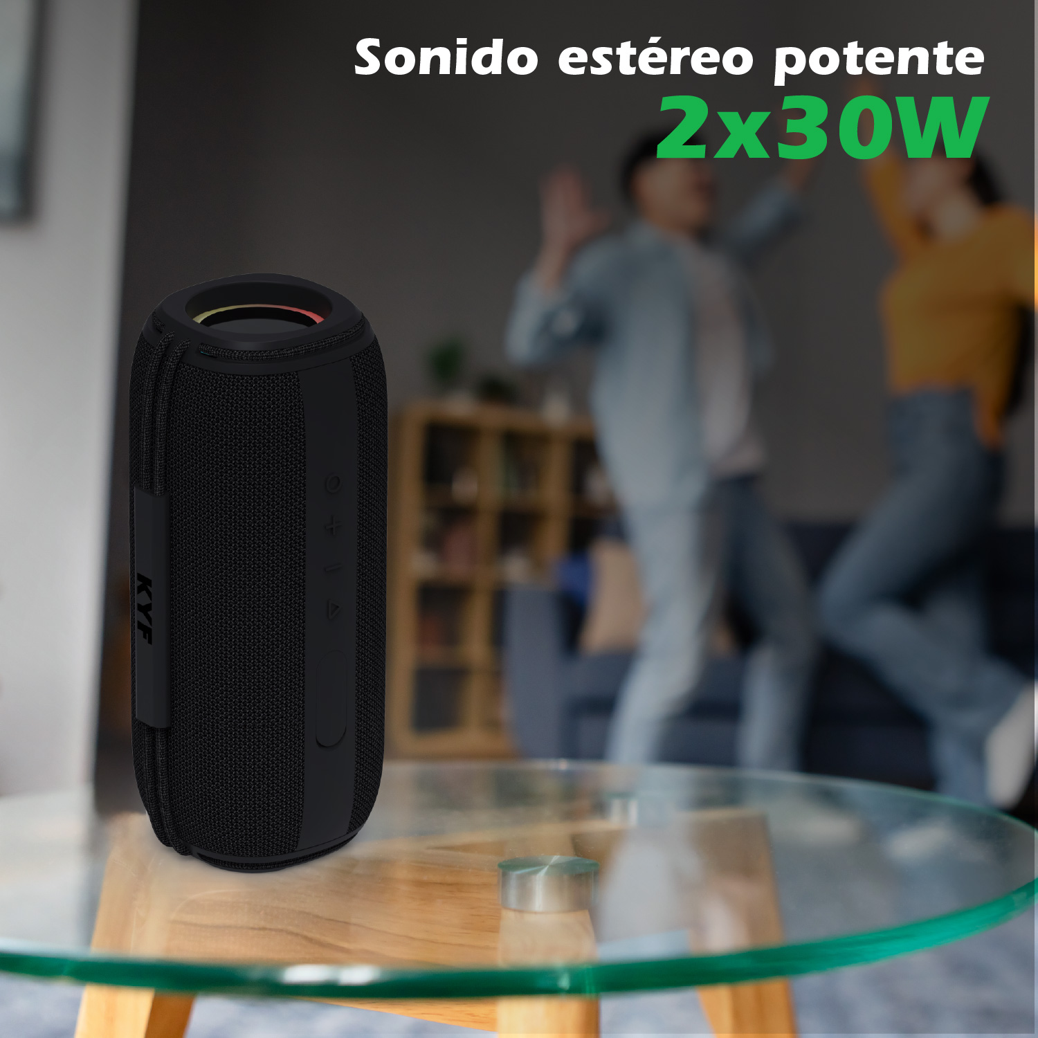 Un altavoz negro sobre una mesa de vidrio. En el fondo, dos personas bailan cerca de un sofá. El texto dice: Sonido estéreo potente 2x30W.