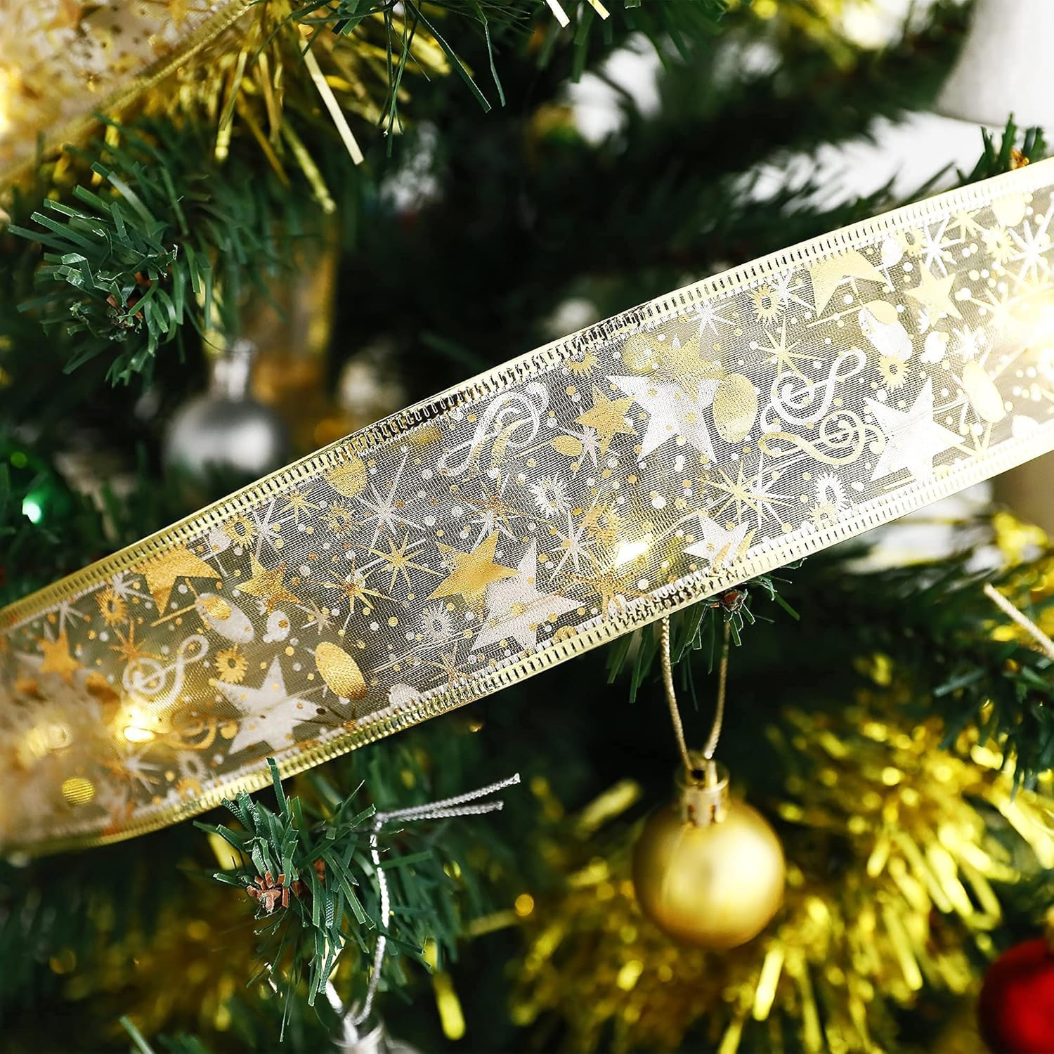 Nahaufnahme eines geschmückten Weihnachtsbaums. Ein goldenes Band mit Sternen und Noten schmückt den Baum.