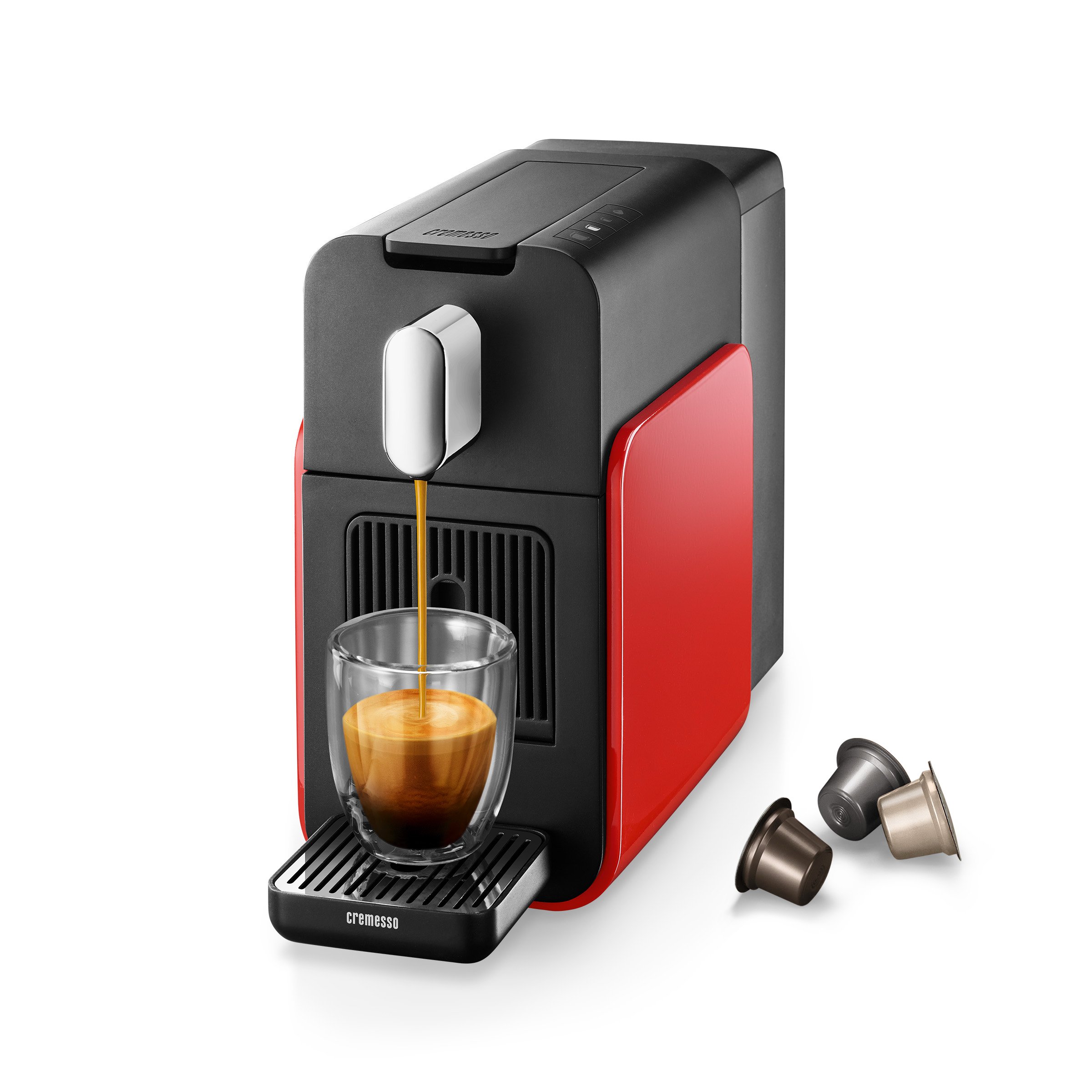 Eine rot-schwarze Kaffeemaschine, die Kaffee in ein Glas gießt. Drei Kaffeekapseln befinden sich rechts.