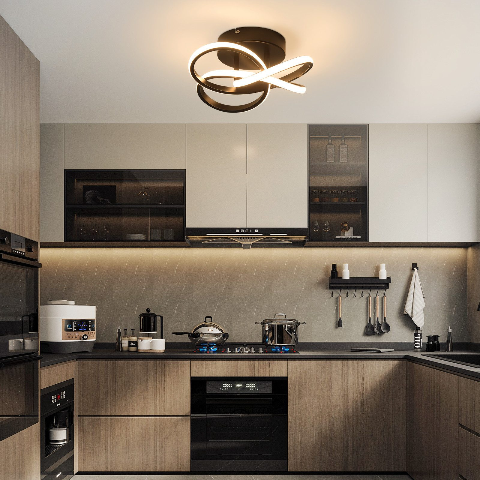 Cucina moderna con illuminazione dall'alto, armadi e elettrodomestici. Un fornello con fiamme blu è sul piano di lavoro.
