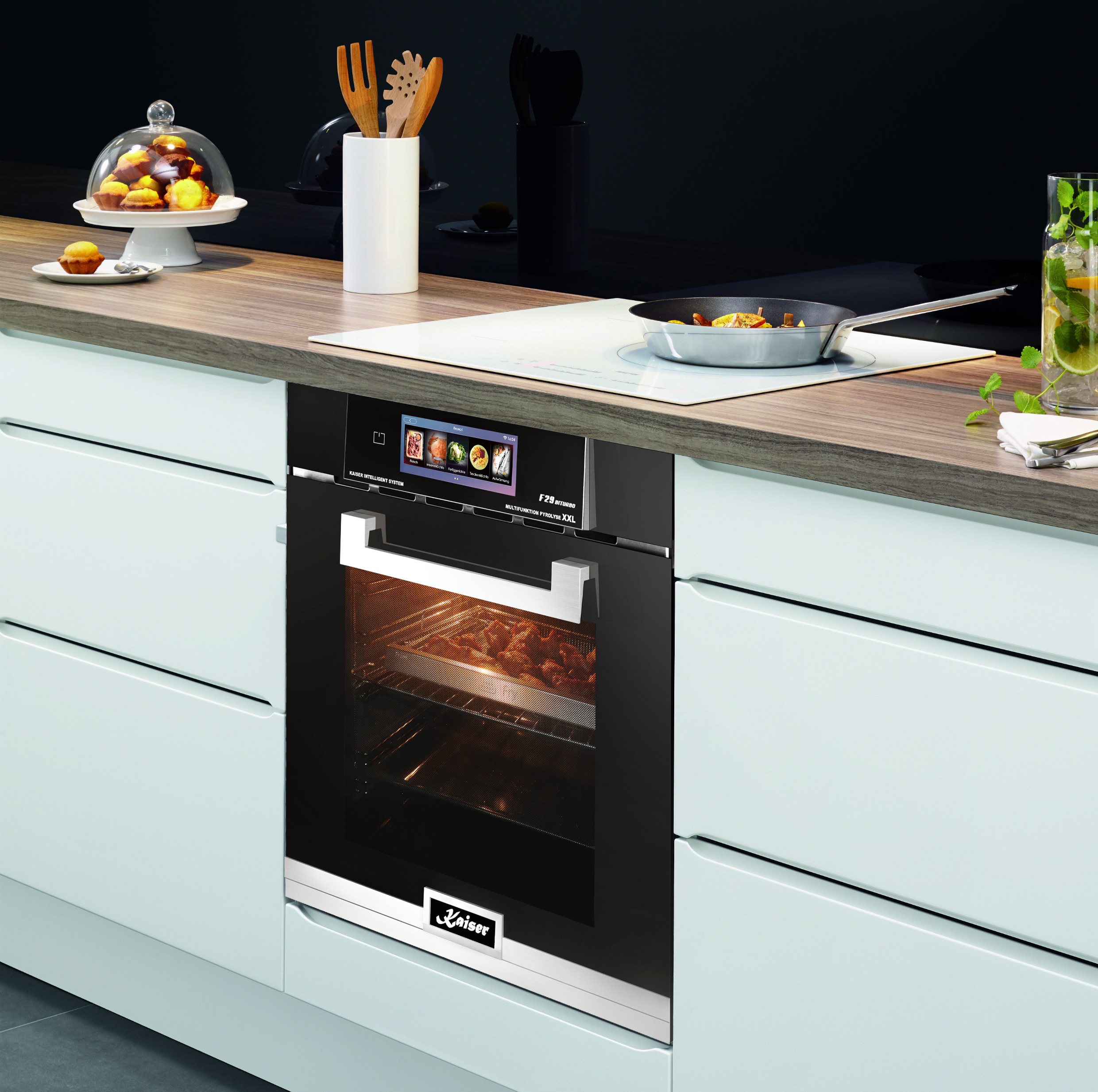 Küchenszene mit Backofen, Holzplatte, Glas Getränk und weißen Schränken. Essen ist drin.
