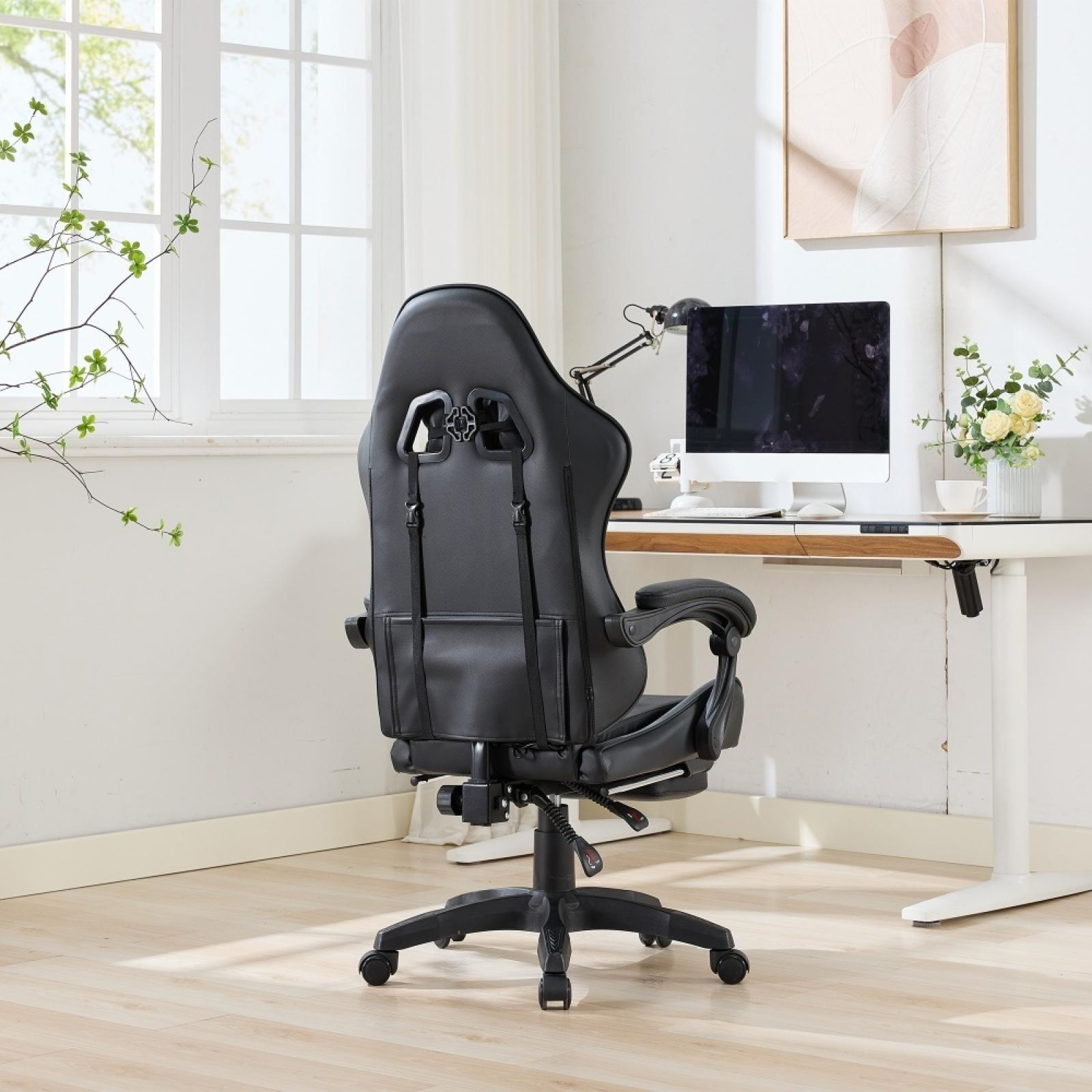 Schwarzer Gaming-Stuhl vor einem Schreibtisch mit Computer, Lampe und Blumen. Fenster im Hintergrund.
