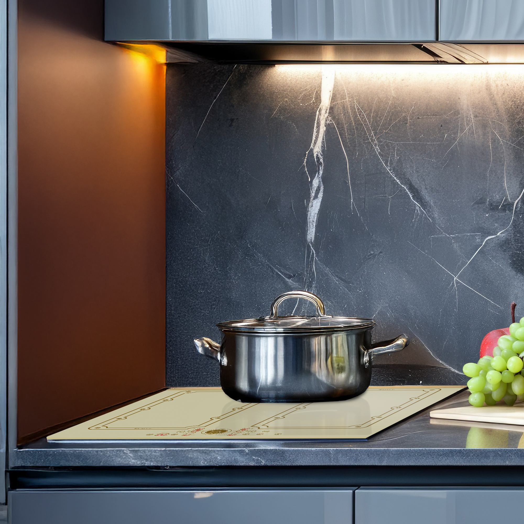 Una scena di cucina con una pentola su un fornello. Uva e una mela sono vicine. Lo sfondo ha un muro scuro.