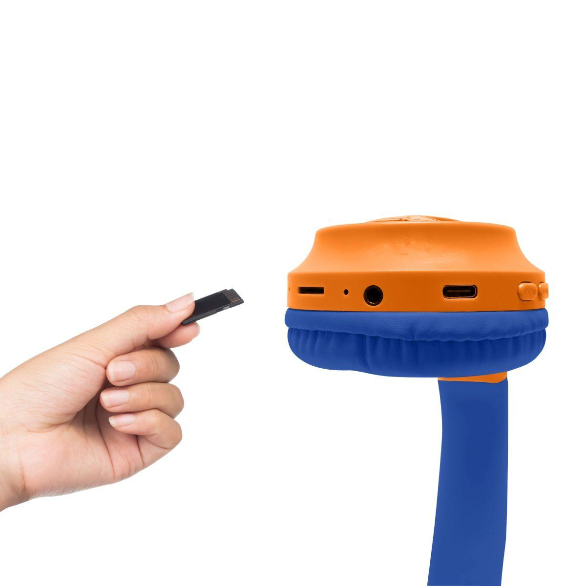 Mano che tiene un adattatore USB nero vicino a cuffie arancioni e blu. Le cuffie hanno un cuscinetto blu e una fascia blu.